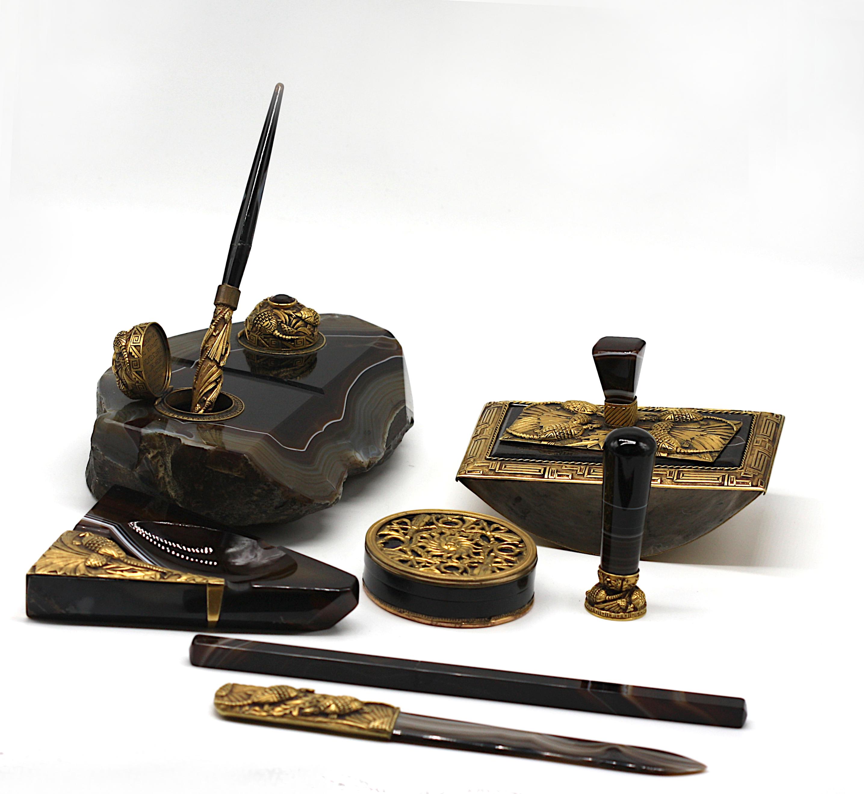 A nine-piece gilt-metal and stone-inlaid assembled desk set
20th century
comprising an inkwell, a pen holder, a stamp box, a pen, a hand blotter, a what not tray, monogramed stamp, letter opener and a silvered box stamped
redmile LONDON
