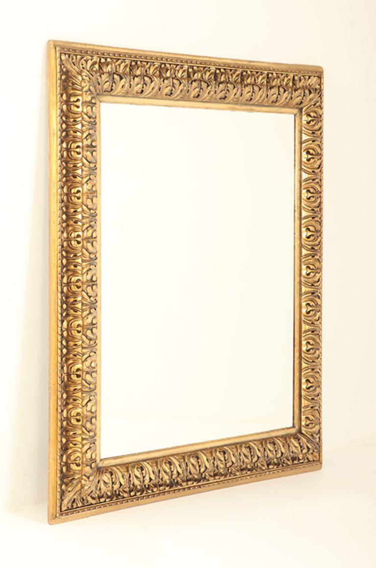 A Nineteenth Century continental relief and gilt carved mirror. In Good Condition For Sale In Philadelphia, PA