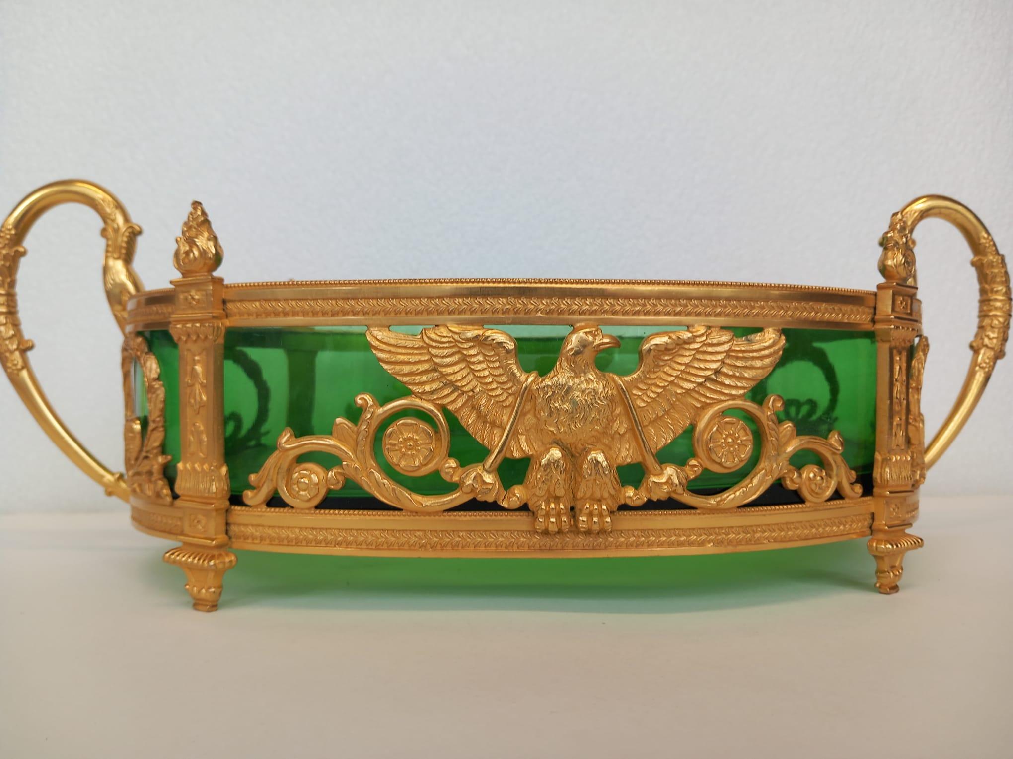 A nineteenth century French gilt bronze and glass jardiniere, the green glass liner sitting in an ormolu body, designed in the Napoleonic fashion with the eagle sitting with its majestic wings spread and the sides decorated with Napoleon’s leaf