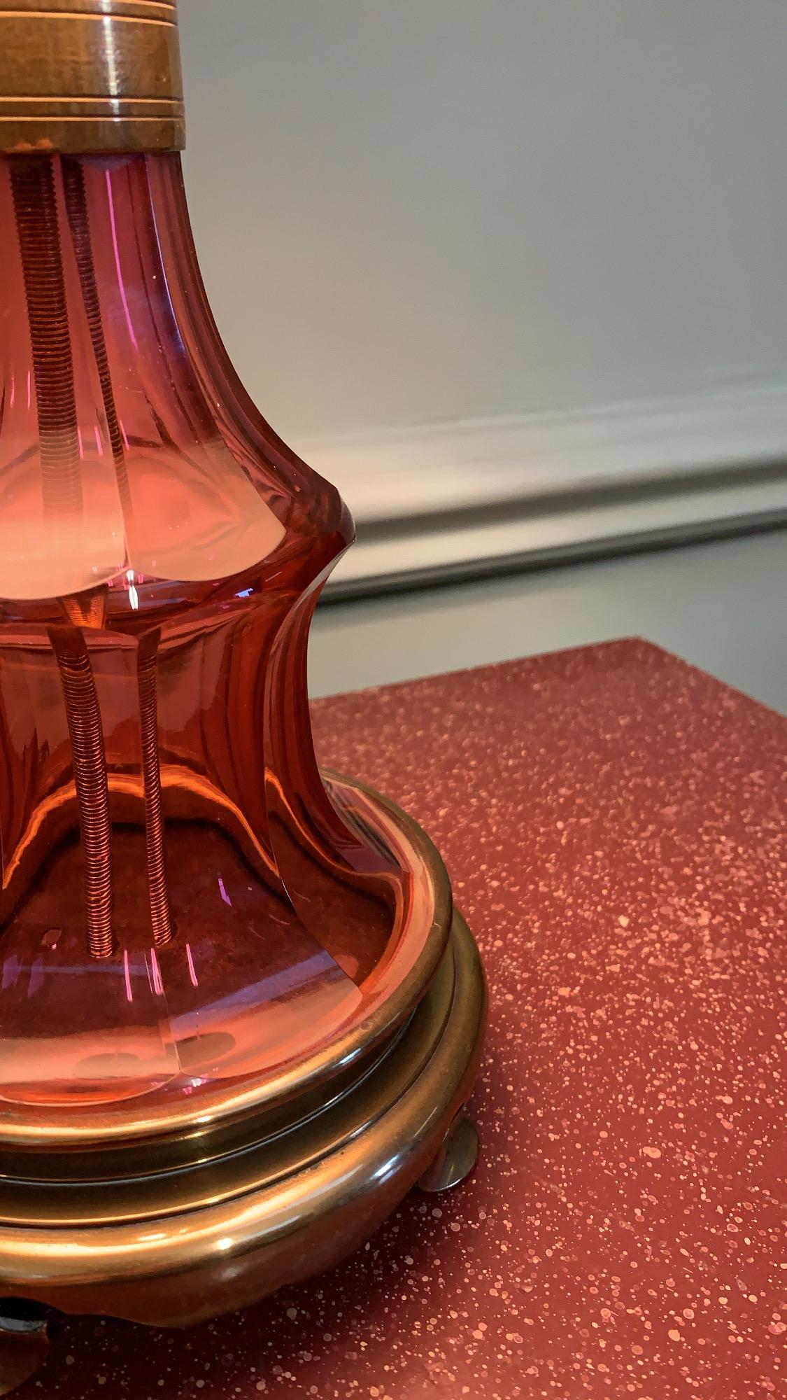 Lampe élégante et galbée en verre rose à facettes sur une base gothique en laiton avec une galerie percée de pieds en forme de pique.

Anglais, milieu du XIXe siècle 

H 25 x L 13 cm    

