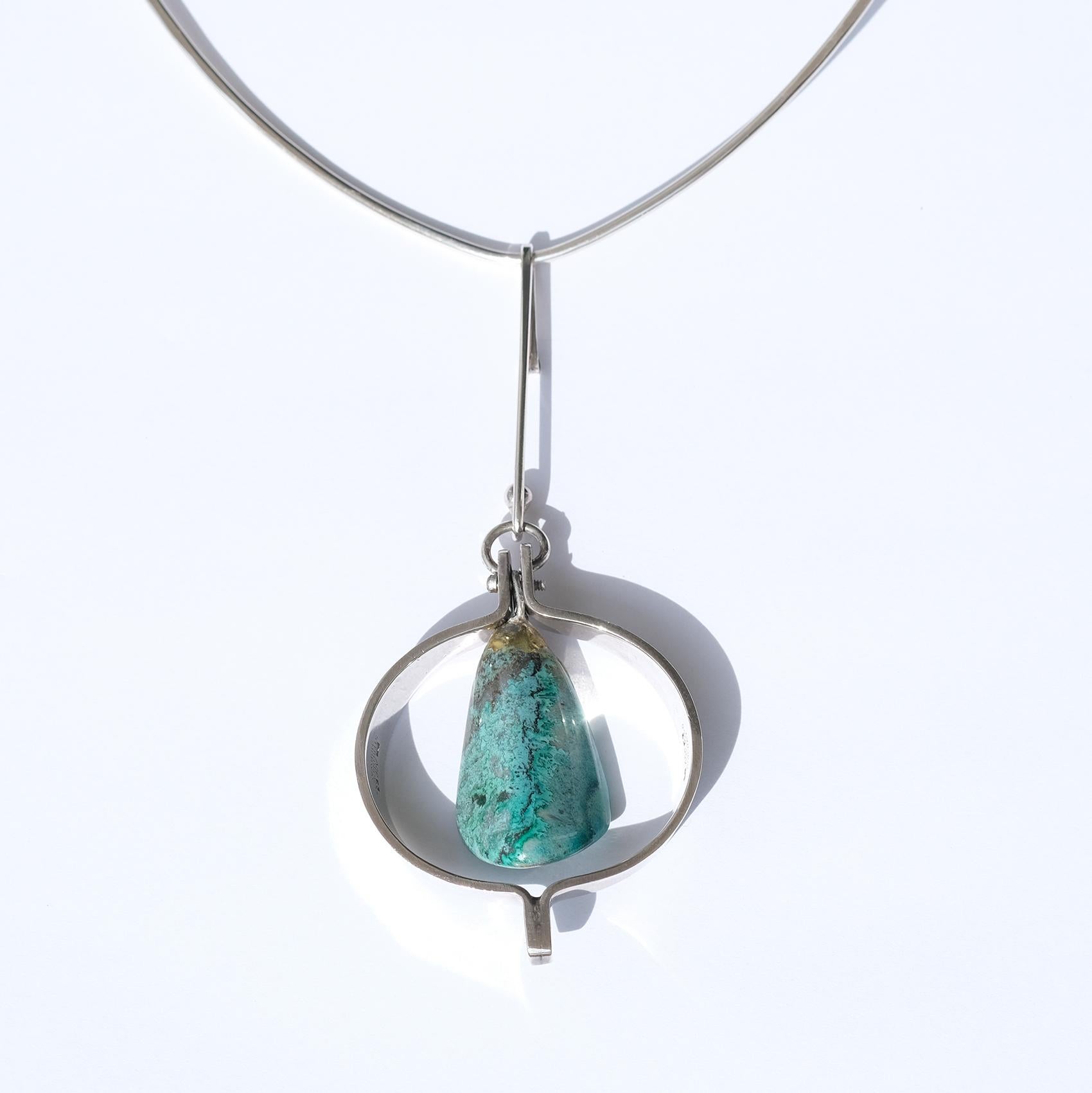 This fixed sterling silver neck ring holds a silver and amozinite stone pendant. The amozinite stone has a waxy, appealing luster which is making you want to touch its smooth surface.

This stone was a popular stone in the use of jewelry during the