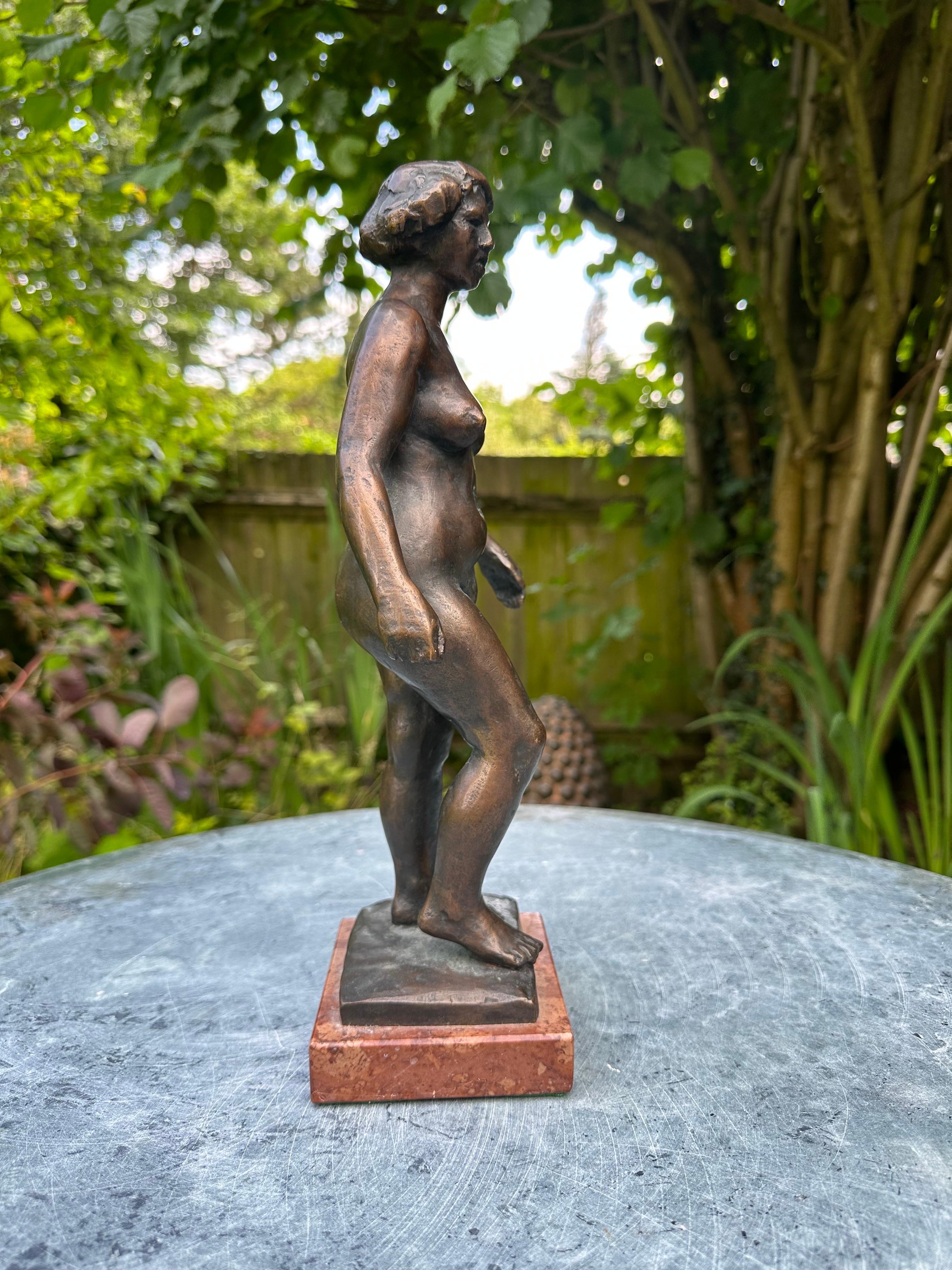 A fine figure of a nude woman standing on a vino rosso marble base signed by unknown artist ML .
