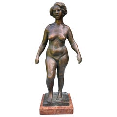 Escultura de bronce de una mujer desnuda.