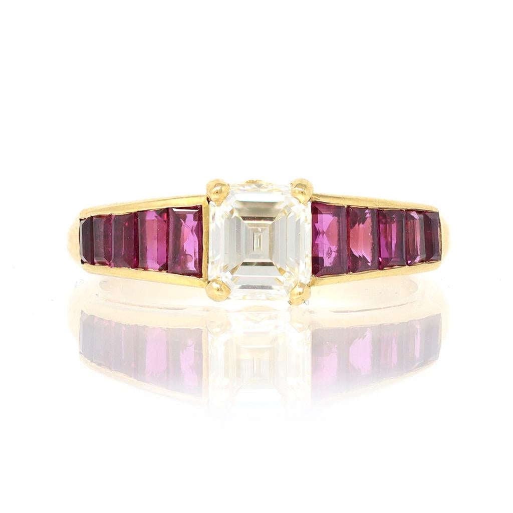 The Asscher cut Solitaire diamond is centered on a mounting featuring step cut rubies and set in 18 Karat yellow gold. The eye clean Asscher cut diamond comes with an EGL Report stating the diamond is K color and SI1 clarity. The mounting is Modern