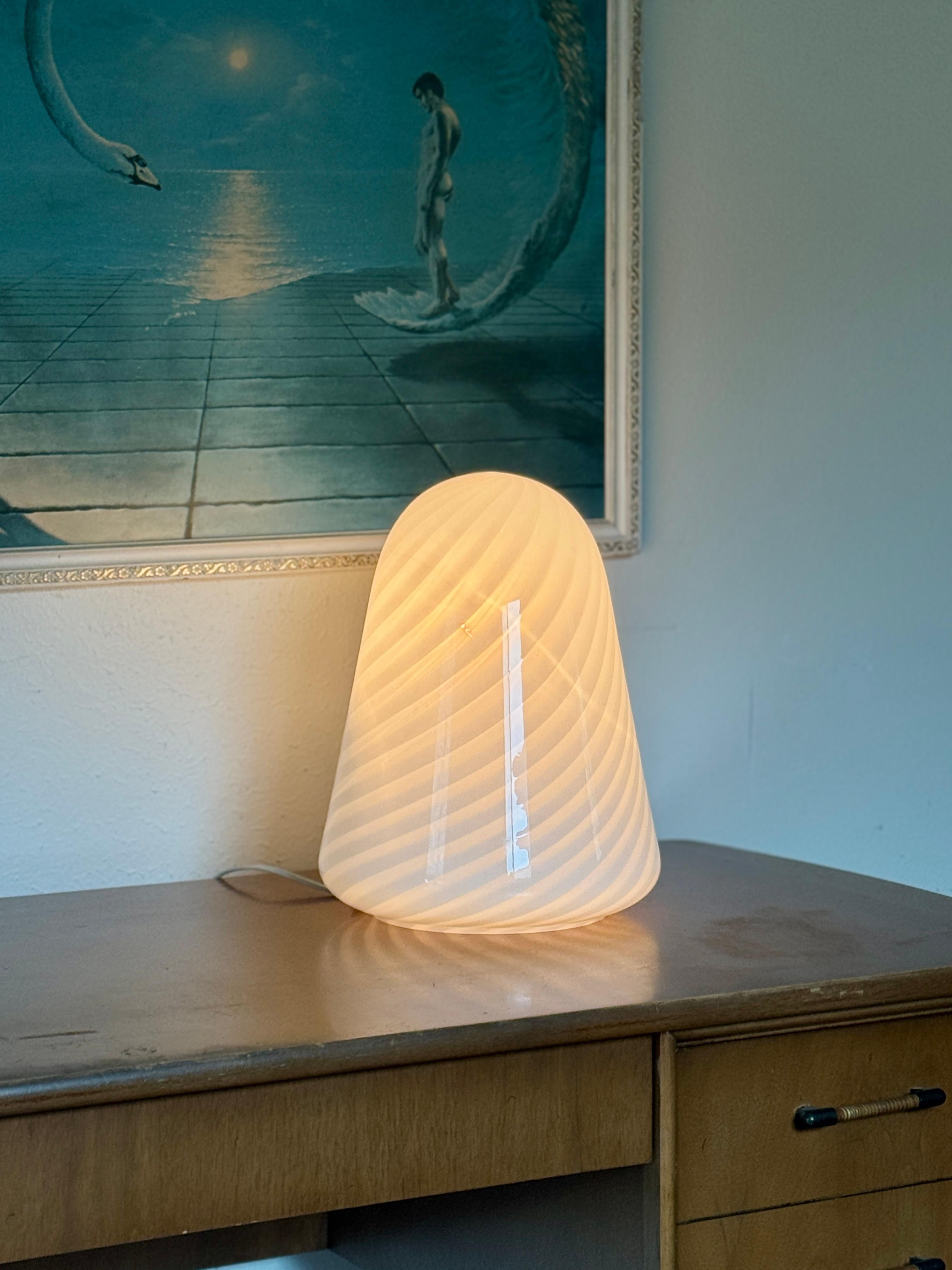 Una lampada in vetro di Murano soffiato a mano, unica nel suo genere, con un motivo a volute, realizzata in Italia, circa negli anni '70. Le creste vorticose non sono solo decorative, ma catturano la luce in movimento, aggiungendo profondità e