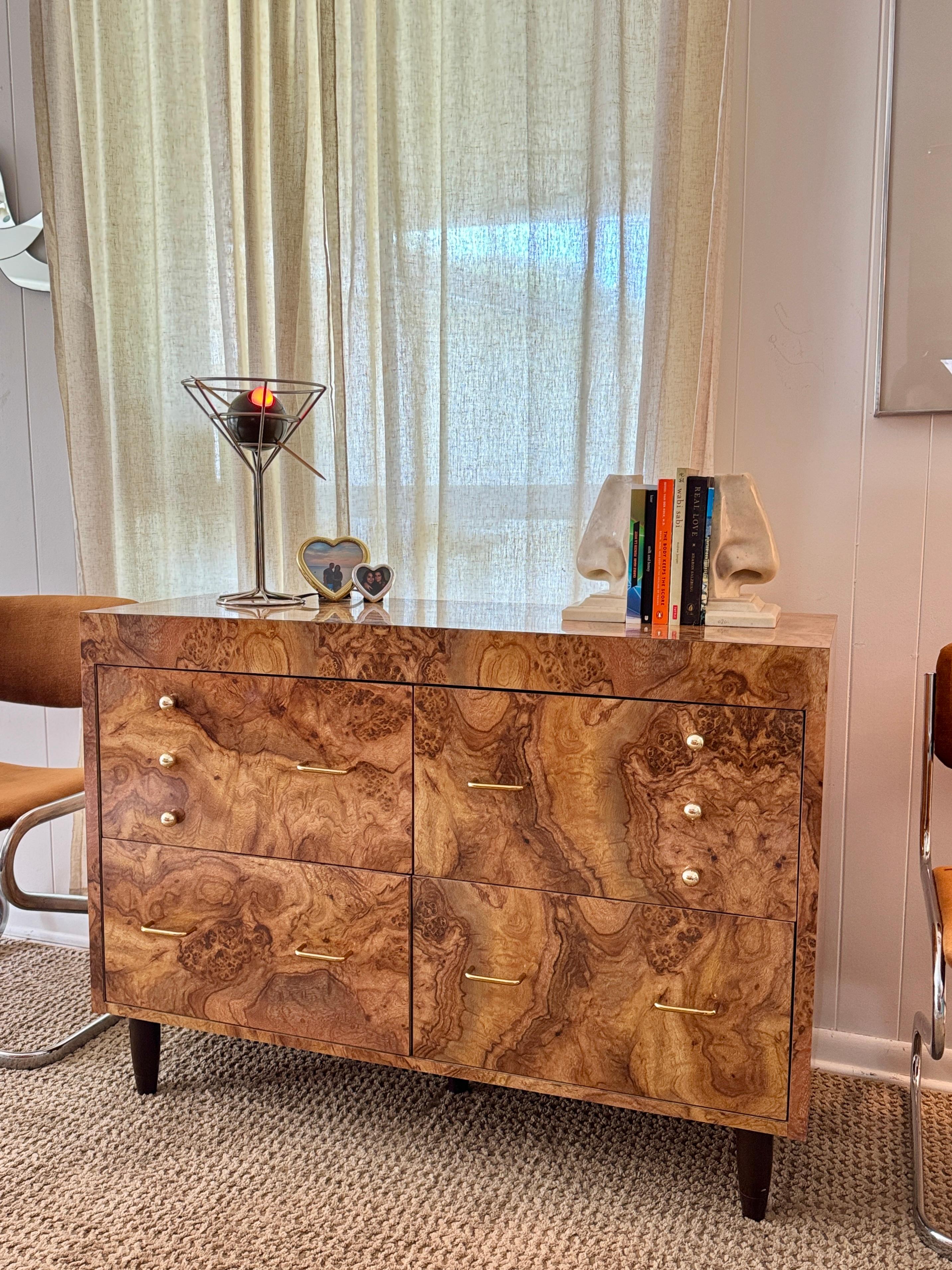 Un mueble vintage de chapa de Burl único en su especie. Cuatro cajones ofrecen un práctico almacenamiento, mientras que la elegante silueta de mediados de siglo mantiene la sensación de pieza atemporal y a medida. Los herrajes de latón recién