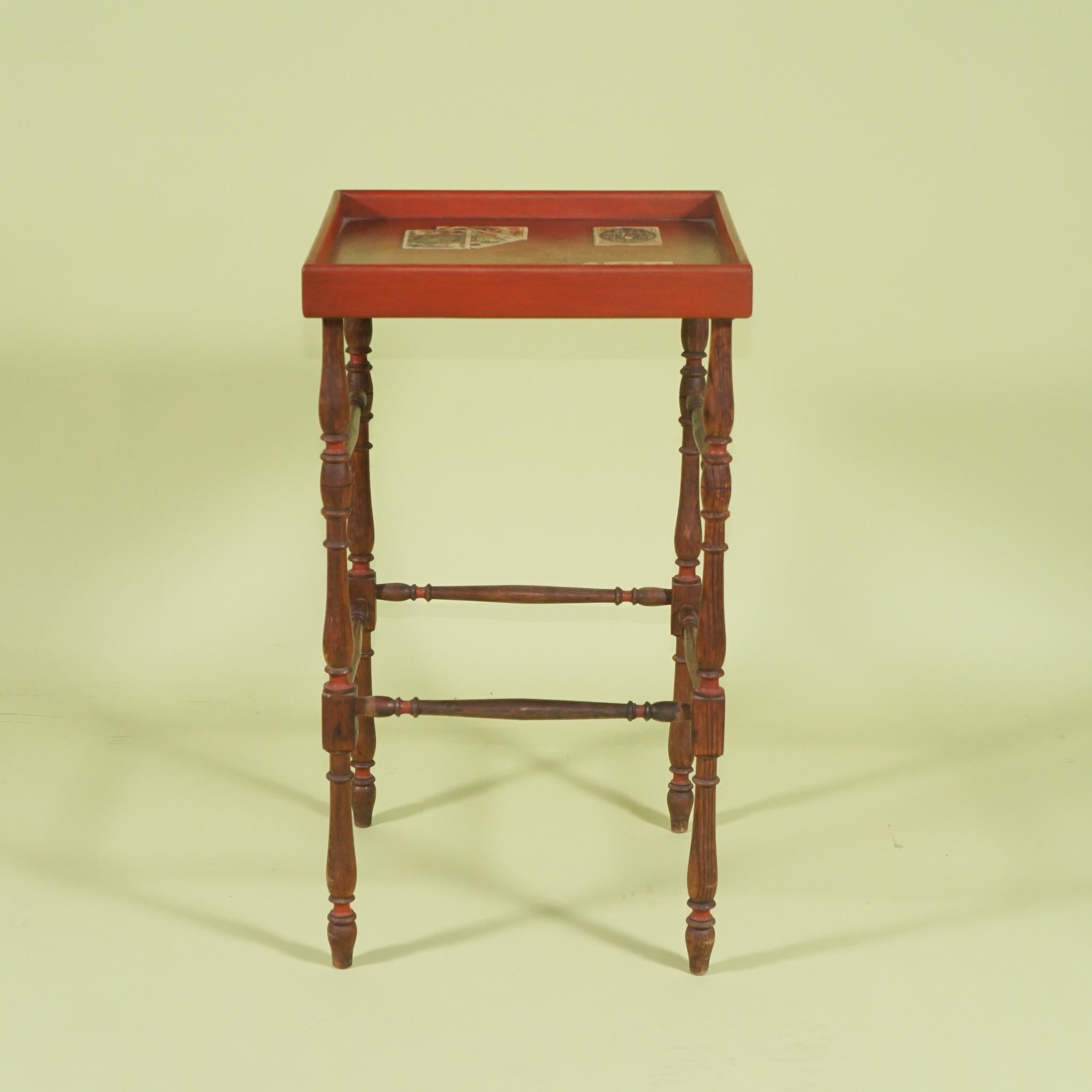 This table crafted from what we believe to be a 19th-century quilt or drying rack cut and configured to accept a top with a galleried edge was then painted and decoupaged with old playing cards. The work was then shaded in a troupe ole manner giving