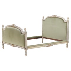 A painted and carved French Louis XV full size bed circa 1800.