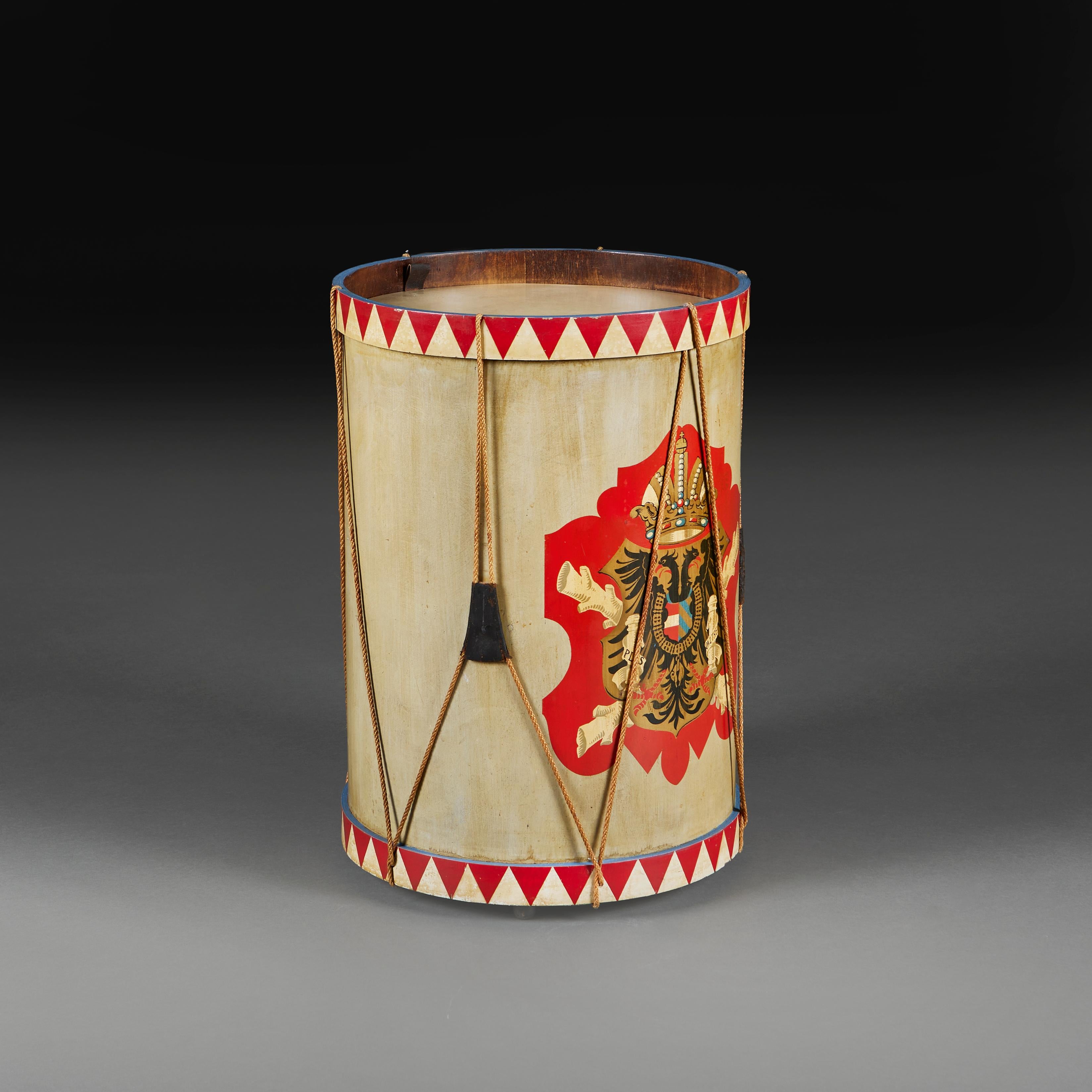Table d'appoint cylindrique inhabituelle en tambour peint, décorée d'un écusson continental, probablement l'aigle des Habsbourg, les bandes supérieure et inférieure étant croisées avec un motif de dent de requin peint, le couvercle amovible révélant