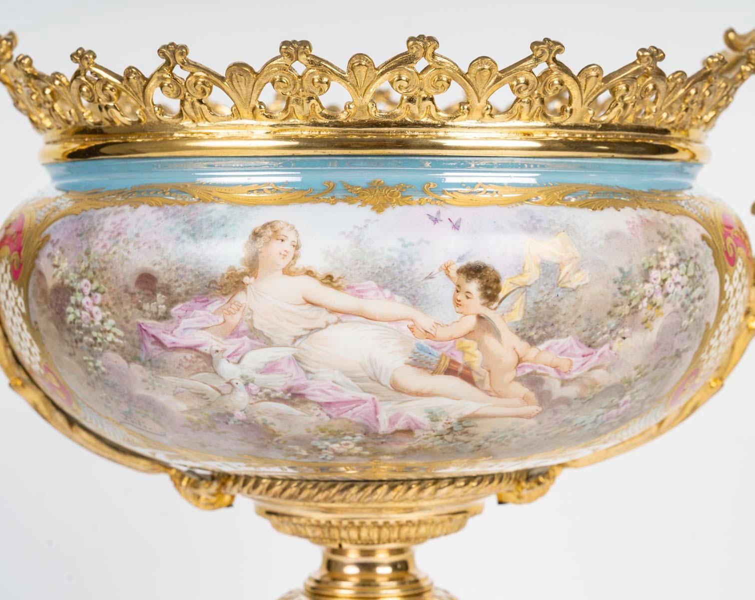 A painted porcelain centrepiece, gilt bronze mounting, 19th century.

A Napoleon III period gilt bronze centrepiece and porcelain bowl painted with a gallant scene on a turquoise blue, pink and gold relief background, 19th century.

h: 36cm, w: