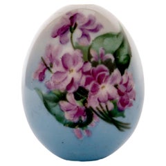 A painted porcelain Easter egg depicting a bunch of Violet flowers, Russia 1890.