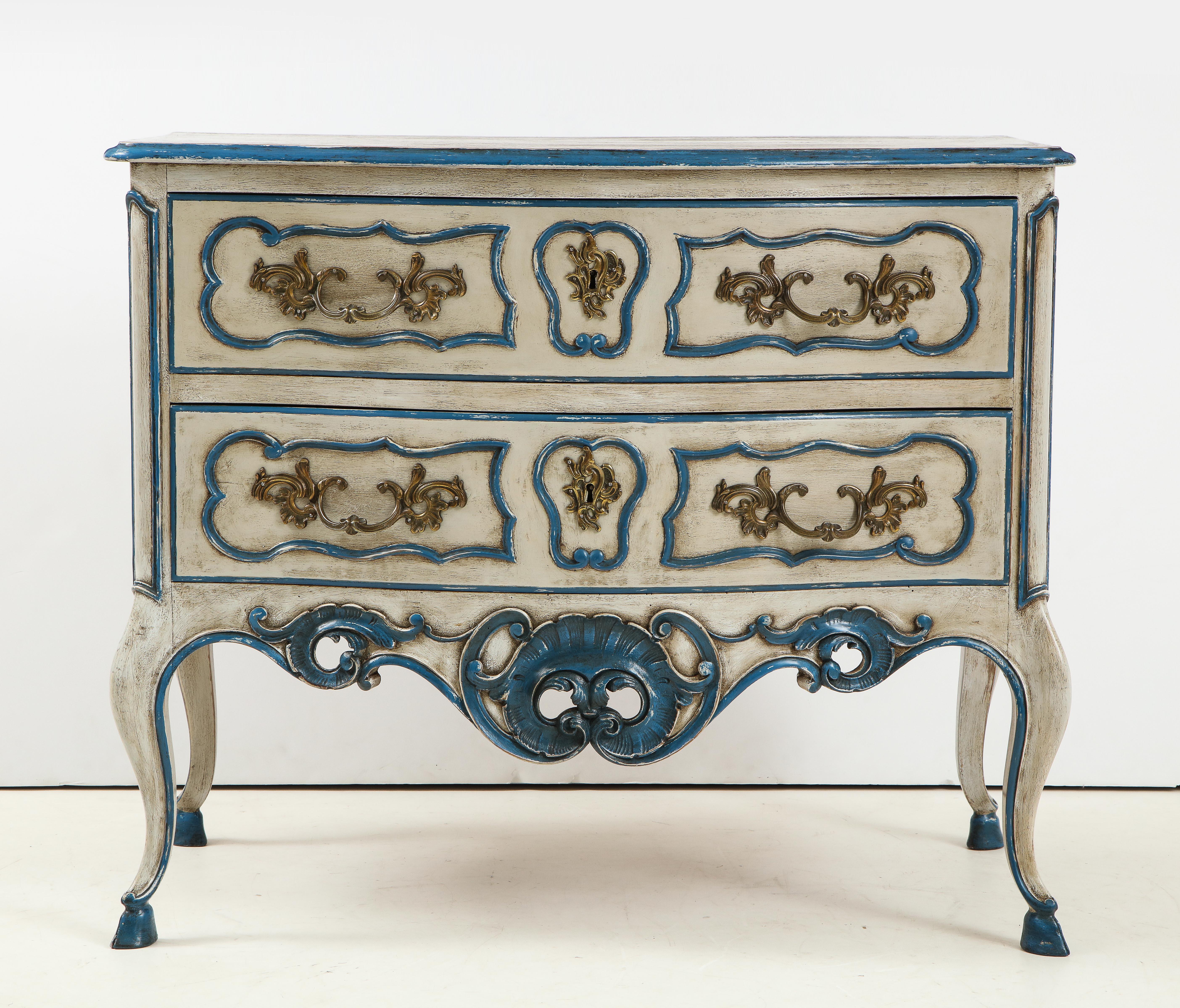 A charming commode from Provence in the Louis XV style. This lovely piece is painted in a soft creamy gray with stunning peacock blue accents. The commode has two drawers with original brass pulls and is raised on cabriole legs.