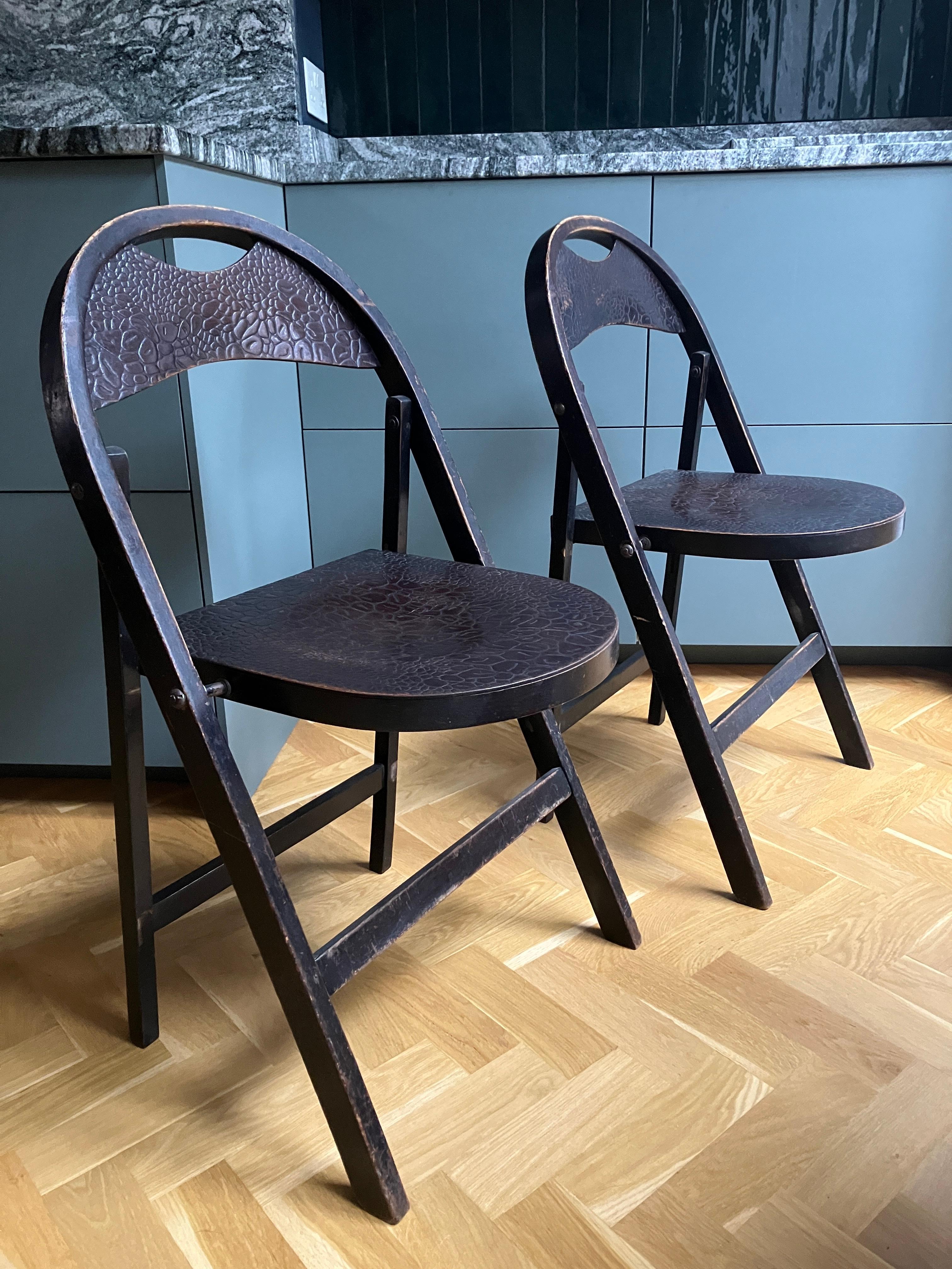 A pair of Bauhaus bentwood crocodile chairs by Thonet. Beech and plywood folding café chairs from the 1930s with crocodile skin embossed seat and back panel in great condition. The embossed pattern was created by running the wood through huge cold