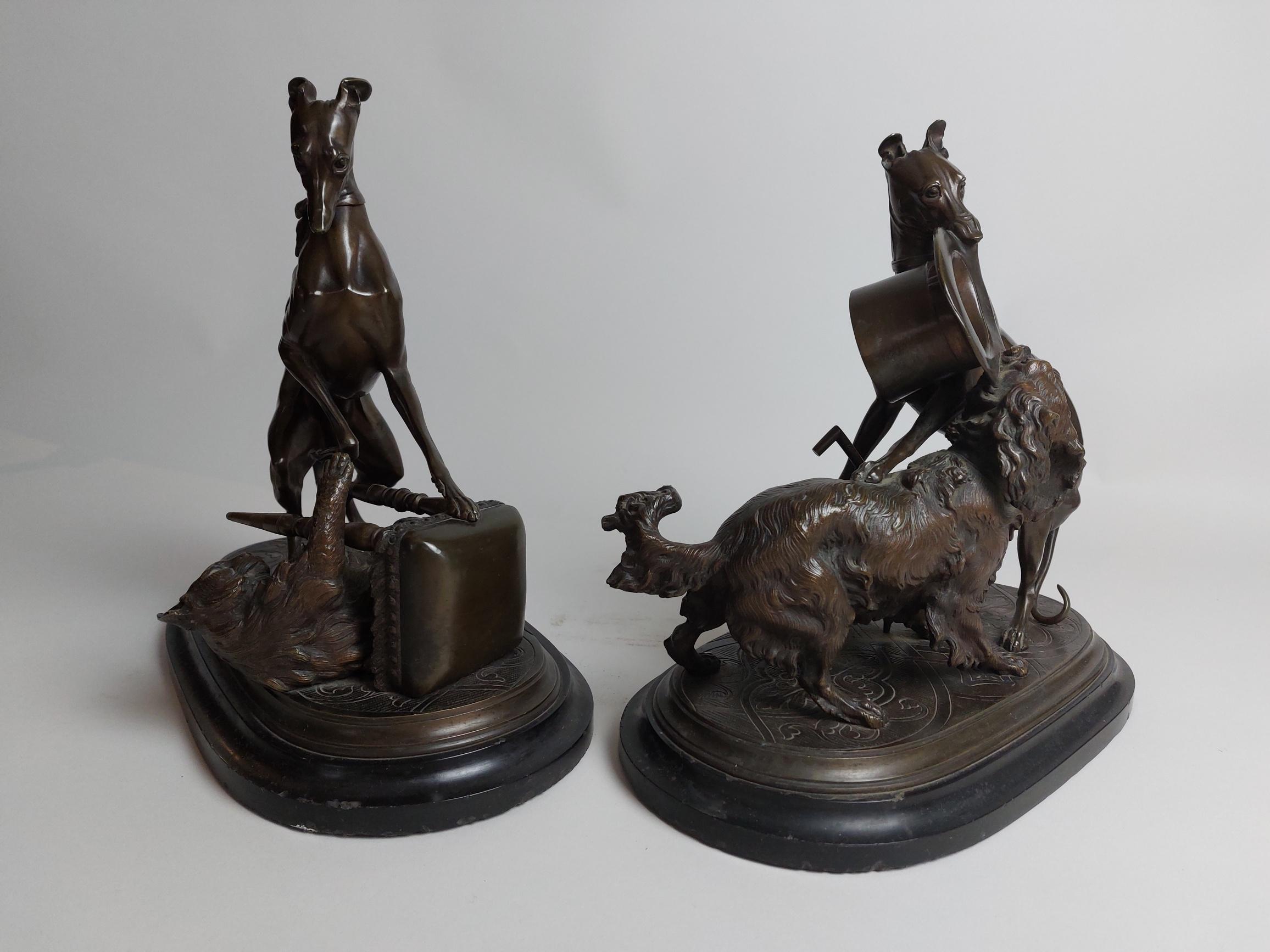 A pair of amusing 19th century bronze dog sculptures of ‘Playful Pets’ by Leblanc Freres.

Two whippets misbehave! One pinning a large maine coon cat under a stool and the other fighting over a hat with a spaniel. 

Leblanc Freres 
Leblanc