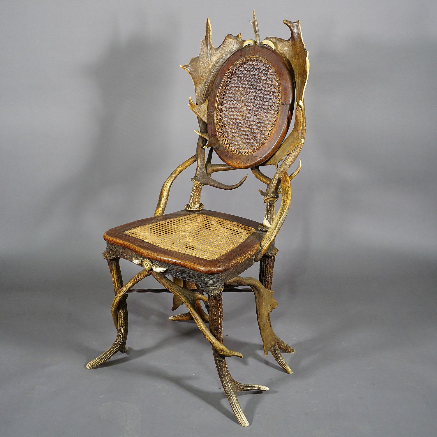 Paire de fauteuils de salon anciens rustiques en bois de cervidé, Allemagne, vers 1900

Paire de chaises anciennes en bois de cerf et de daim. Elles sont ornées d'une rose en corne tournée et de défenses de sanglier. L'assise et le dossier sont en