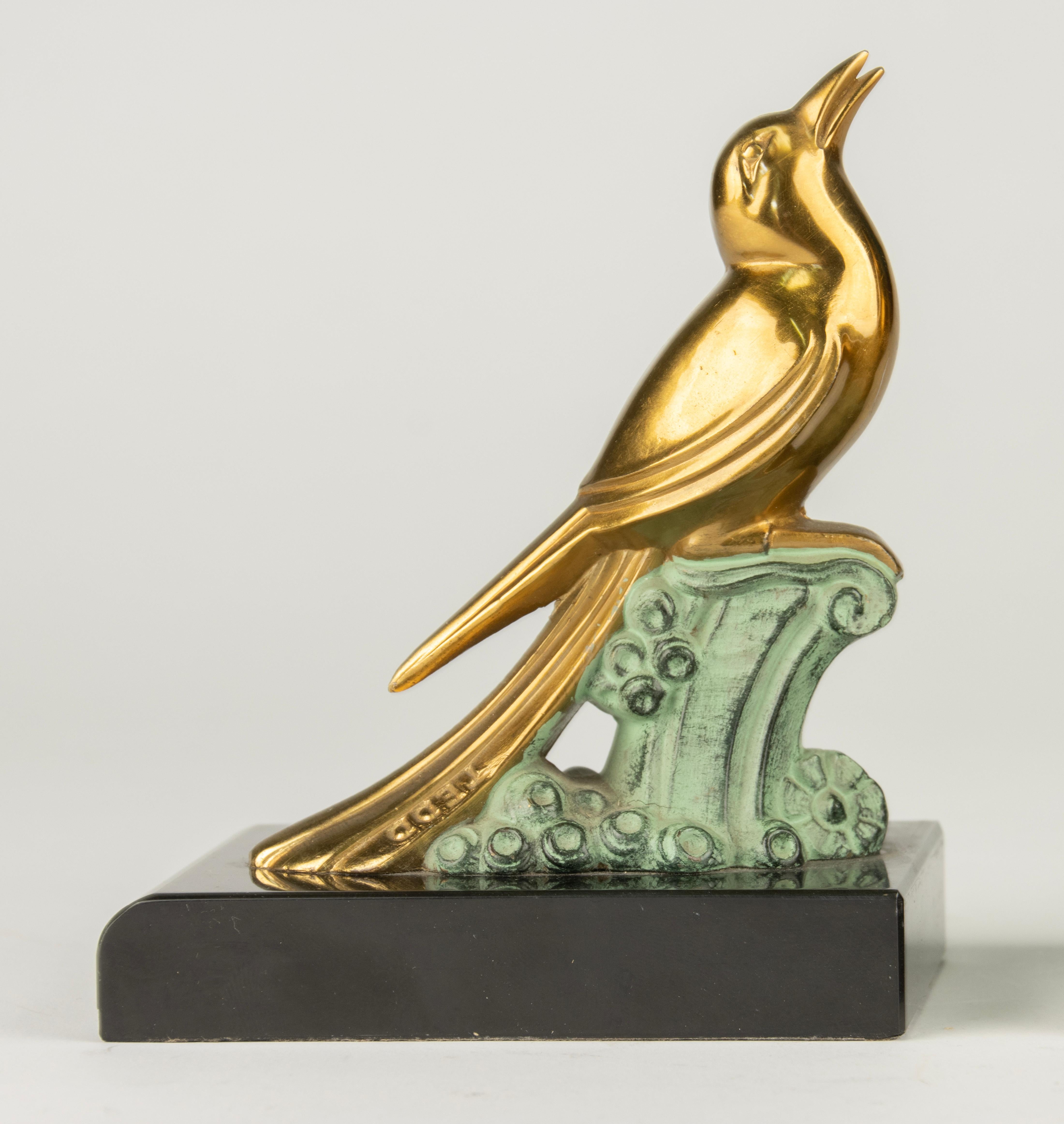 A lovely pair of Art Deco period bookends with birds figurines on a black marble plinth. These are made of spelter, patinated in gold and bronze color. The figurines are marked 'TEDD'. The set is in good condition with normal signs of