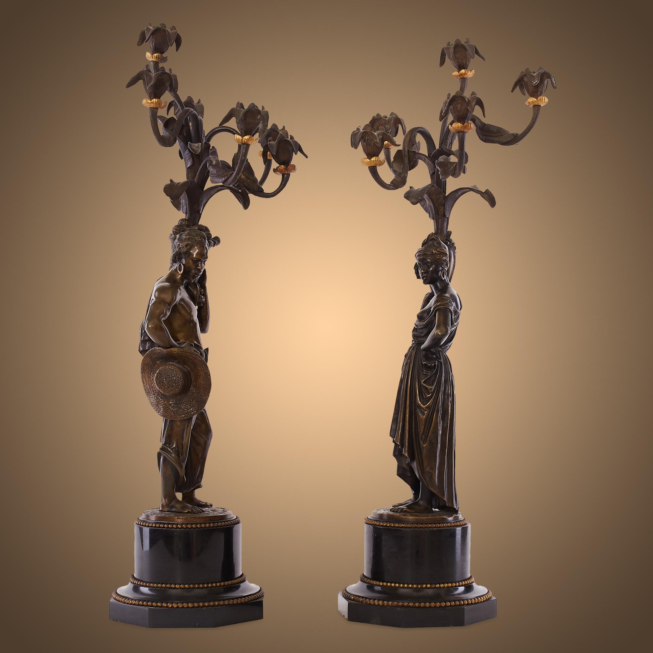 These finely cast 19th-century figural candelabras were made from gilded and burnished bronze, each mounted on Belgian black marble bases and signed by Charles Cumberworth. The sculptures are modelled after African villagers. The female figure is