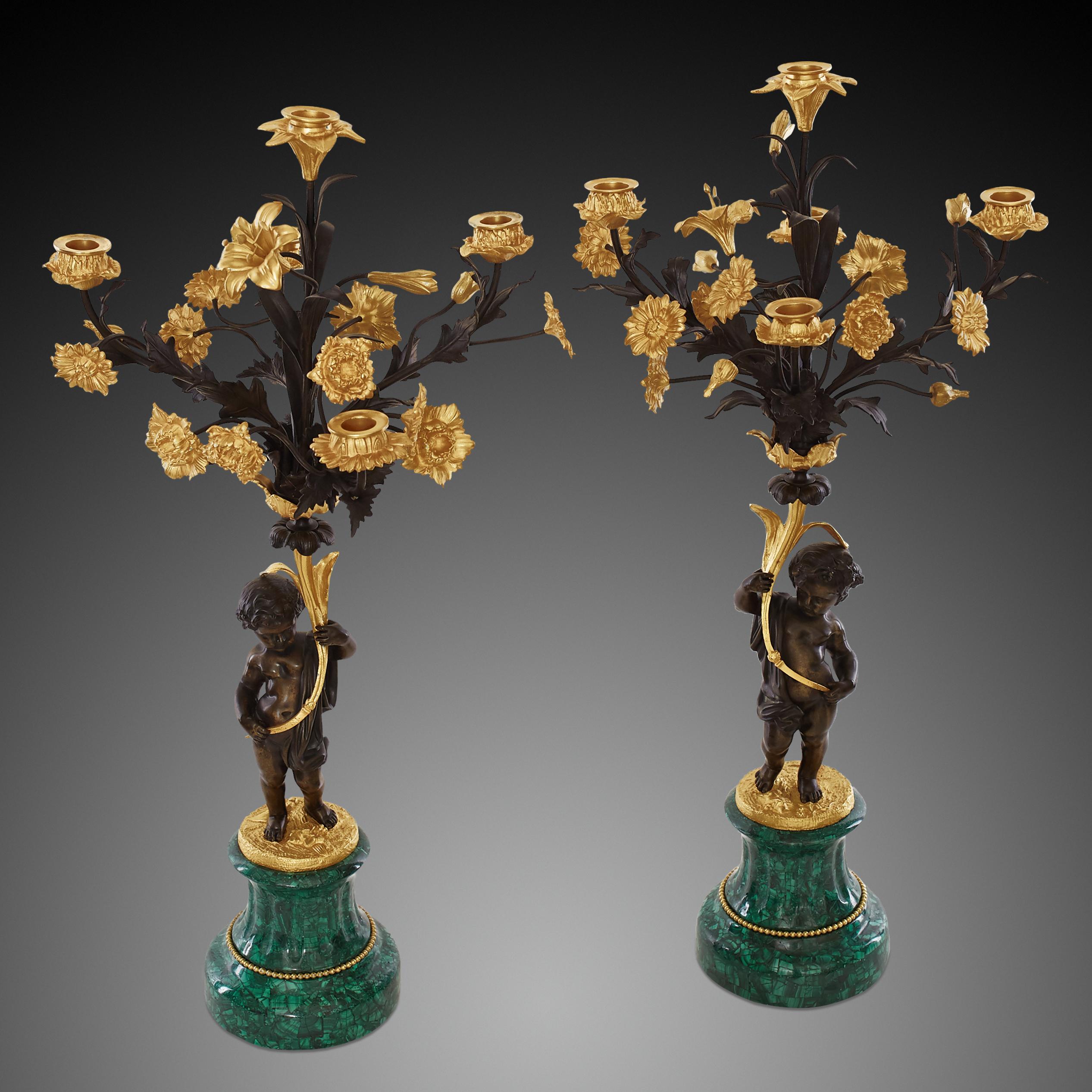 Ein Paar fünfarmige Kerzenleuchter
Napoleonischer Stil.
Engel aus patinierter Bronze, die einen Blumenstrauß aus vergoldeter Bronze halten
mit geschwungenen und beblätterten Armen. Das Ganze steht auf einem Sockel aus Malachit. Eine wichtige