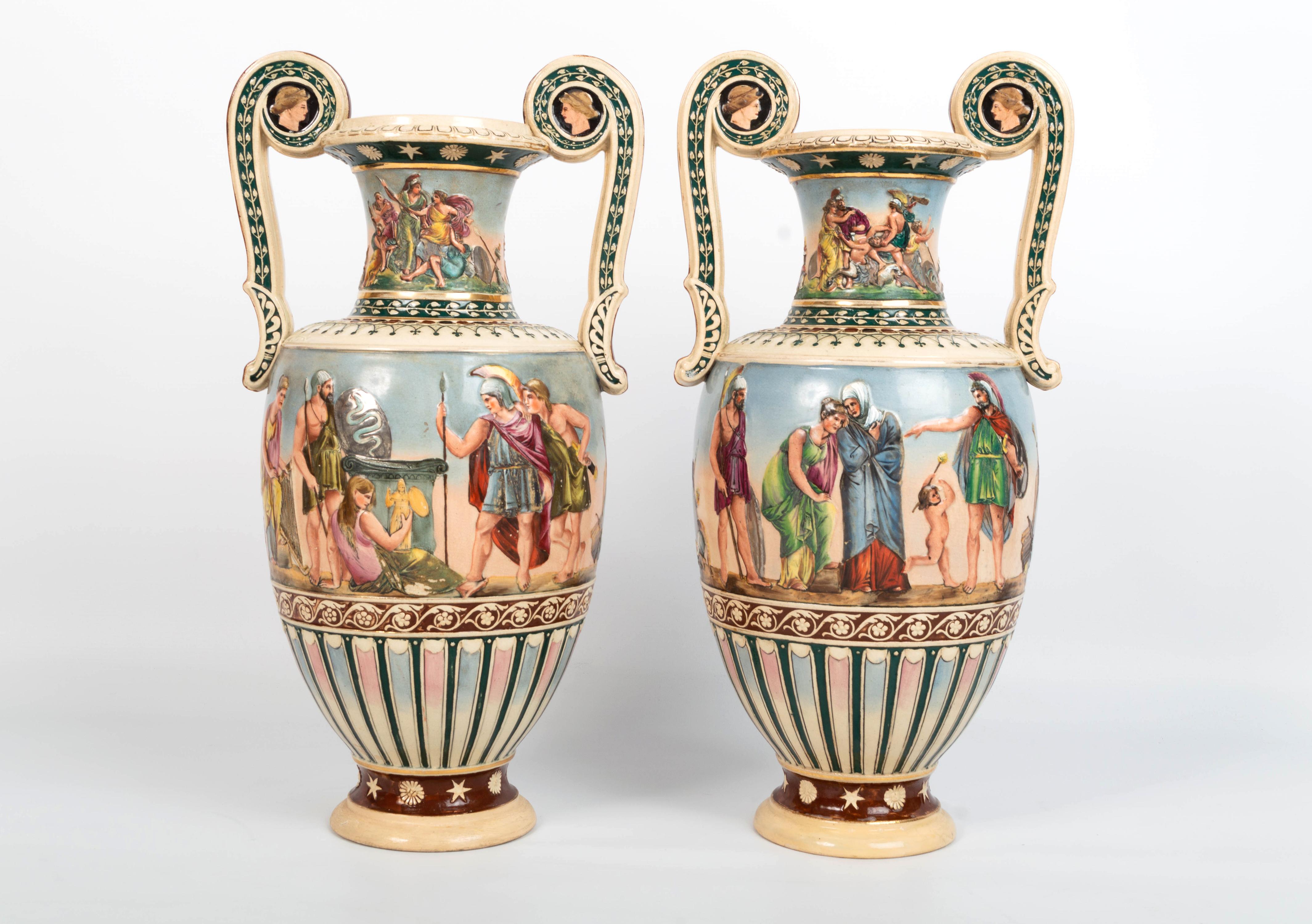 Pair of English 19th century Greek Revival vases
England, C.1830
Staffordshire pottery

A pair of pottery vases decorated in a Grecian style with figures in relief. 
Each Vase of baluster outline with twin scroll handles, ending on a circular