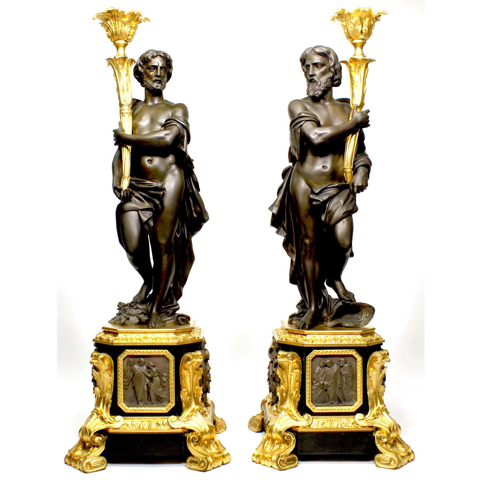 A very fine pair of French 19th century neoclassical Greco-Roman style patinanted bronze and ormolu mounted figural candelabra by Henri Picard (French, Active from 1831-1864). The large and impressive pair of single-light candelabra, each with a
