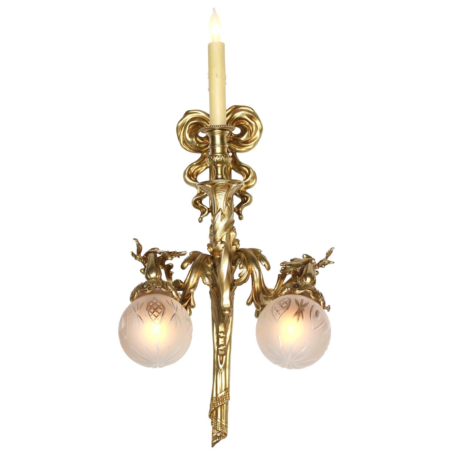 Paire d'appliques murales à trois lumières en bronze doré et verre soufflé de la Belle Époque. Ces élégantes appliques murales sont dotées chacune d'une paire de bras de lumière à volutes d'acanthe et de fleurs et d'une paire d'abat-jour en verre