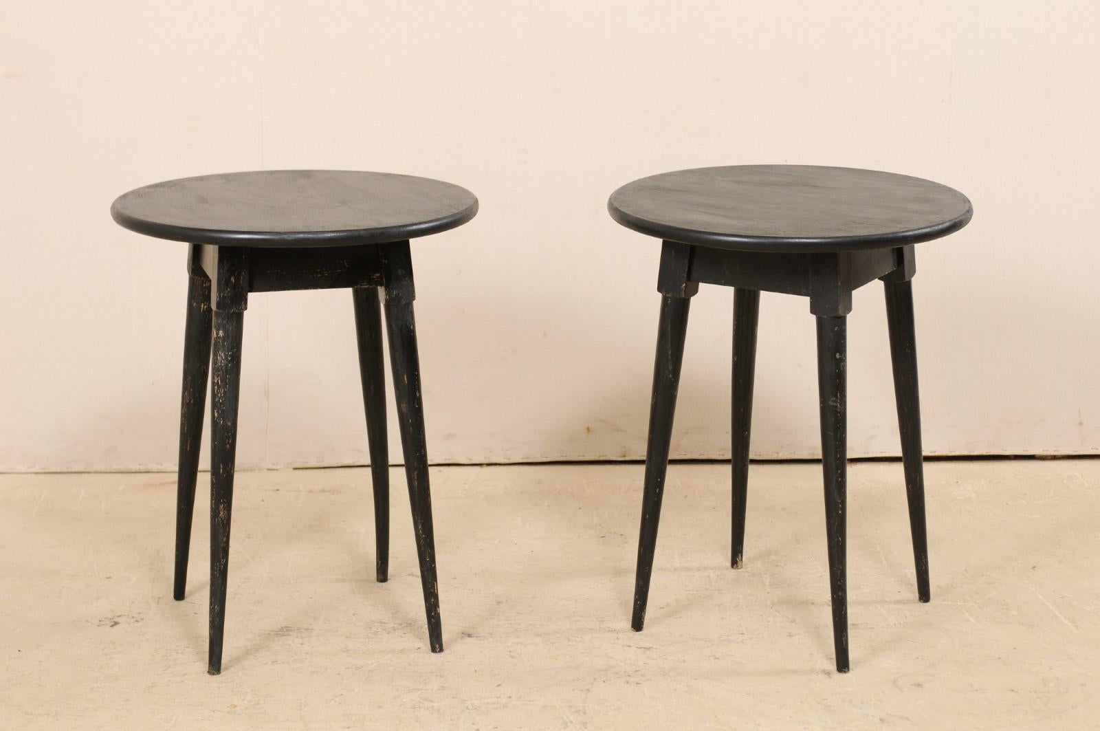 A pair of French painted wood side tables from the mid 20th century. This pair of mid-century side tables from France each feature a circular top (a later addition to these pieces) which are raised upon a squared apron and four tapering legs which