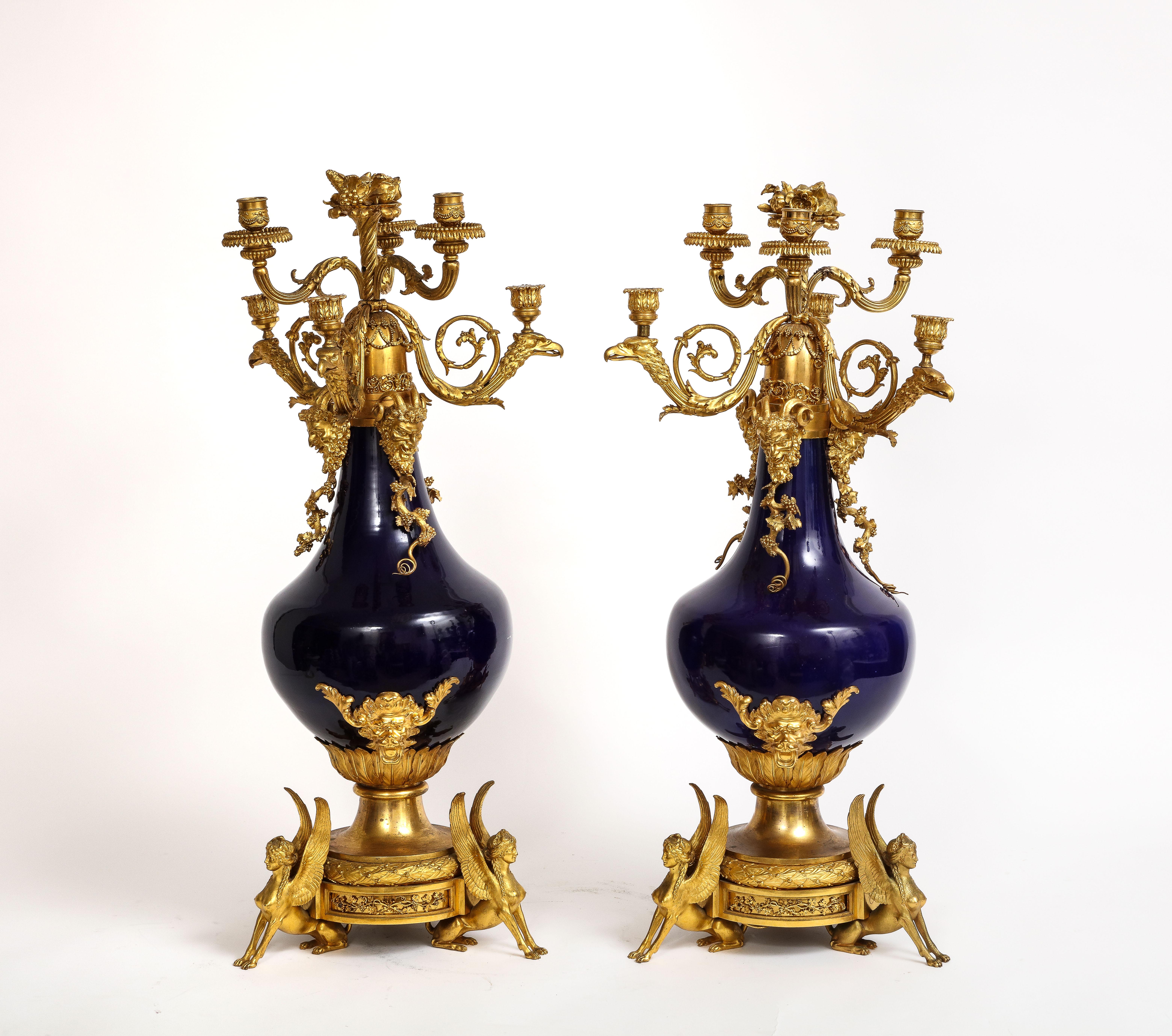 Une paire très rare et hautement unique de candélabres français en porcelaine bleue montés sur bronze doré, Att. Henry Dasson.  Nous vous présentons une paire de candélabres montés en bronze doré en porcelaine française.  Henry Dasson est réputé
