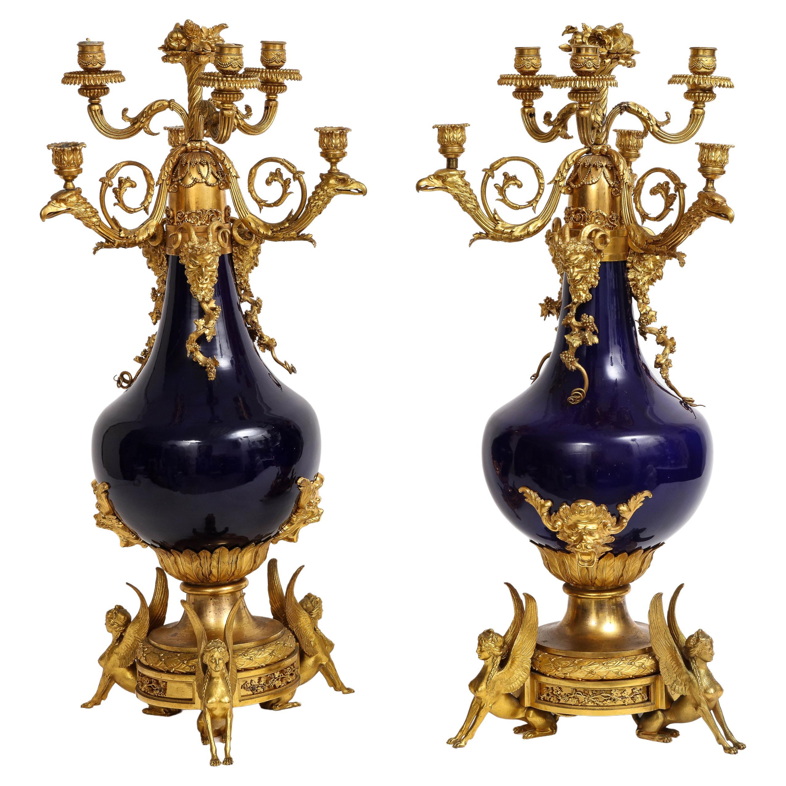 Paire de candélabres français en porcelaine bleue montés en bronze doré, att. Henry Dasson