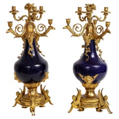 Pareja de candelabros franceses de porcelana azul montados en ormolu, Att. Henry Dasson
