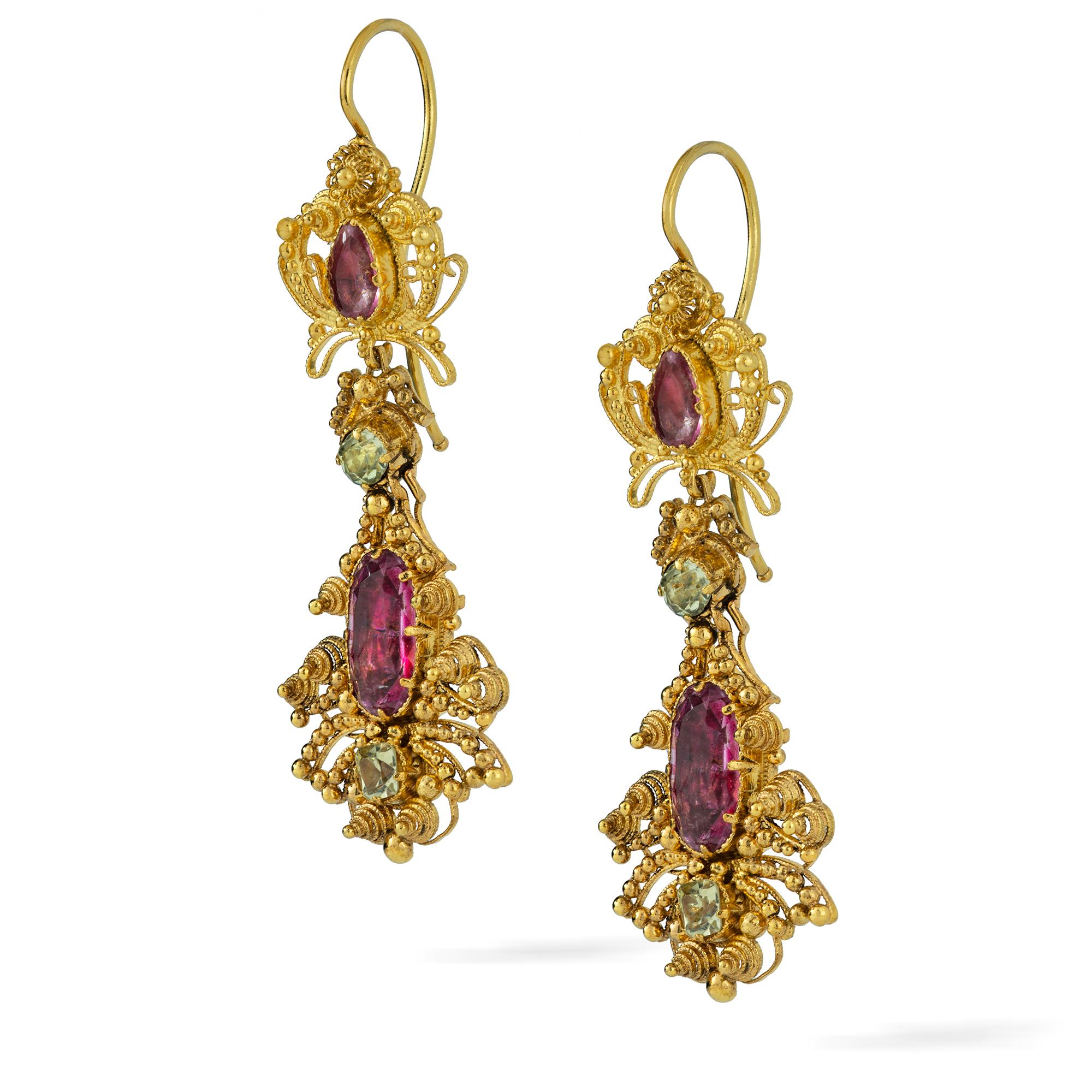 A pair Georgian topaz drop earrings, the top set with a pear-shaped pink topaz, surrounded by gold filigree decorations, suspending a larger oval pink topaz in a similar surround, the topazes weighing approximately a total of 3.0 carats, with two