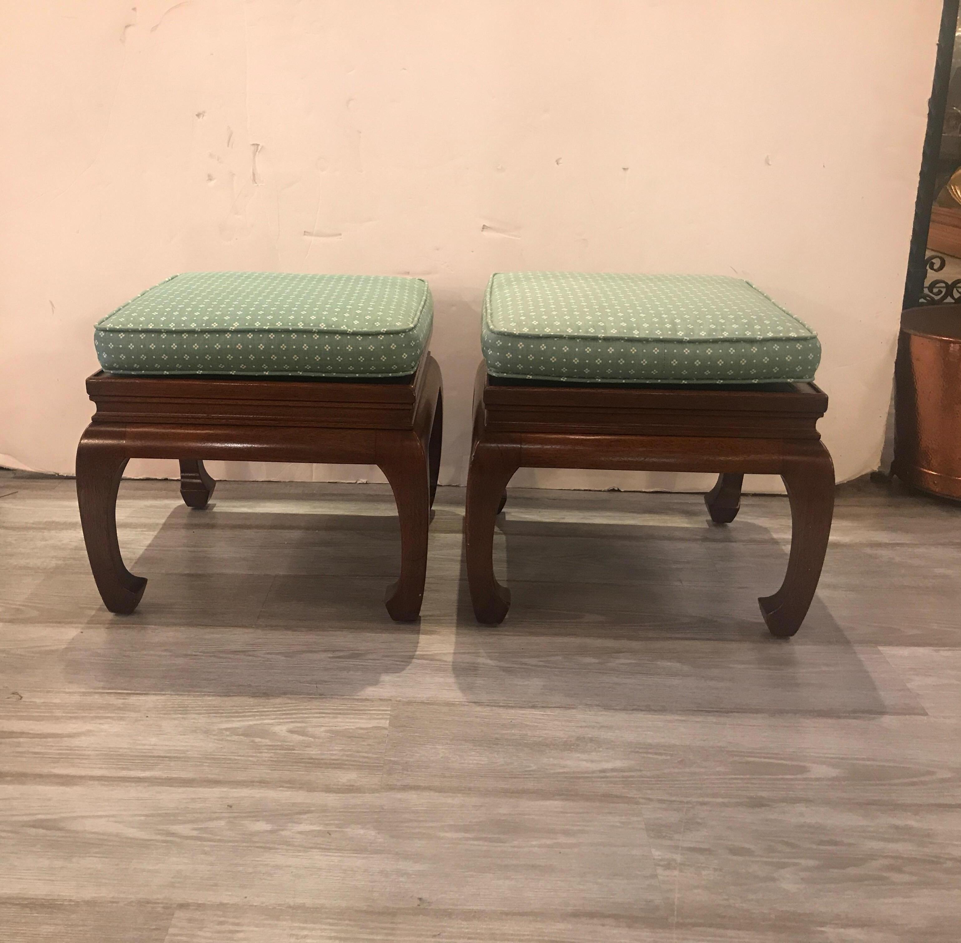 A pair of Classic Asian styled walnut benches or stands. Vintage 1970s with the traditional turned under trunk legs. The stands or benches come with a seat cushion with a clean fabric which should be recovered to suit the new interior. The height