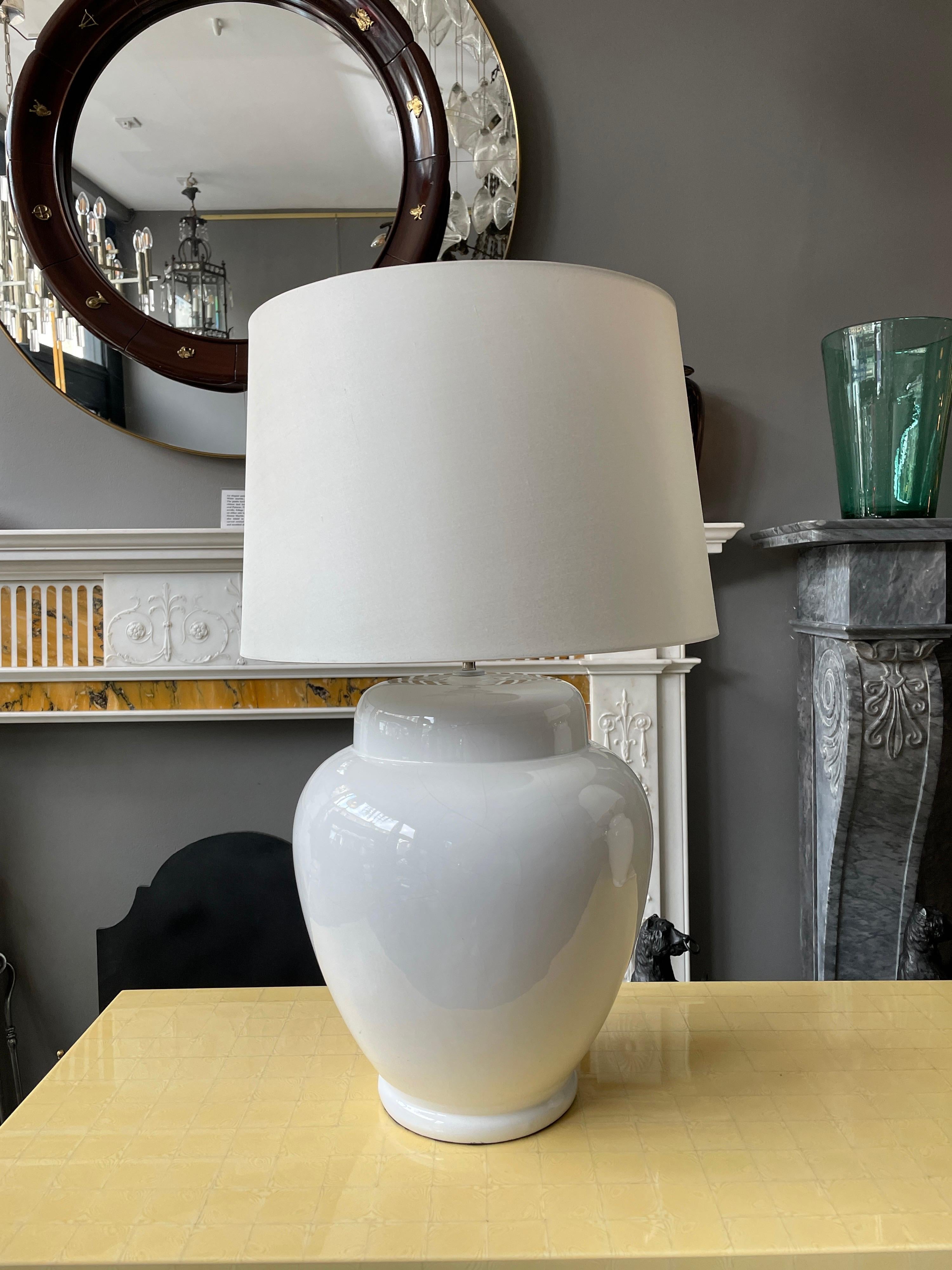A large pair of table lamps in white porcelain, with off white silk shades. Labeled made in Italy, re wired with new fittings. Some lines in the glaze. Purchased from Ciancimino in London in the 70's. 

Measurements with Shades 66cm h x 40cm w.