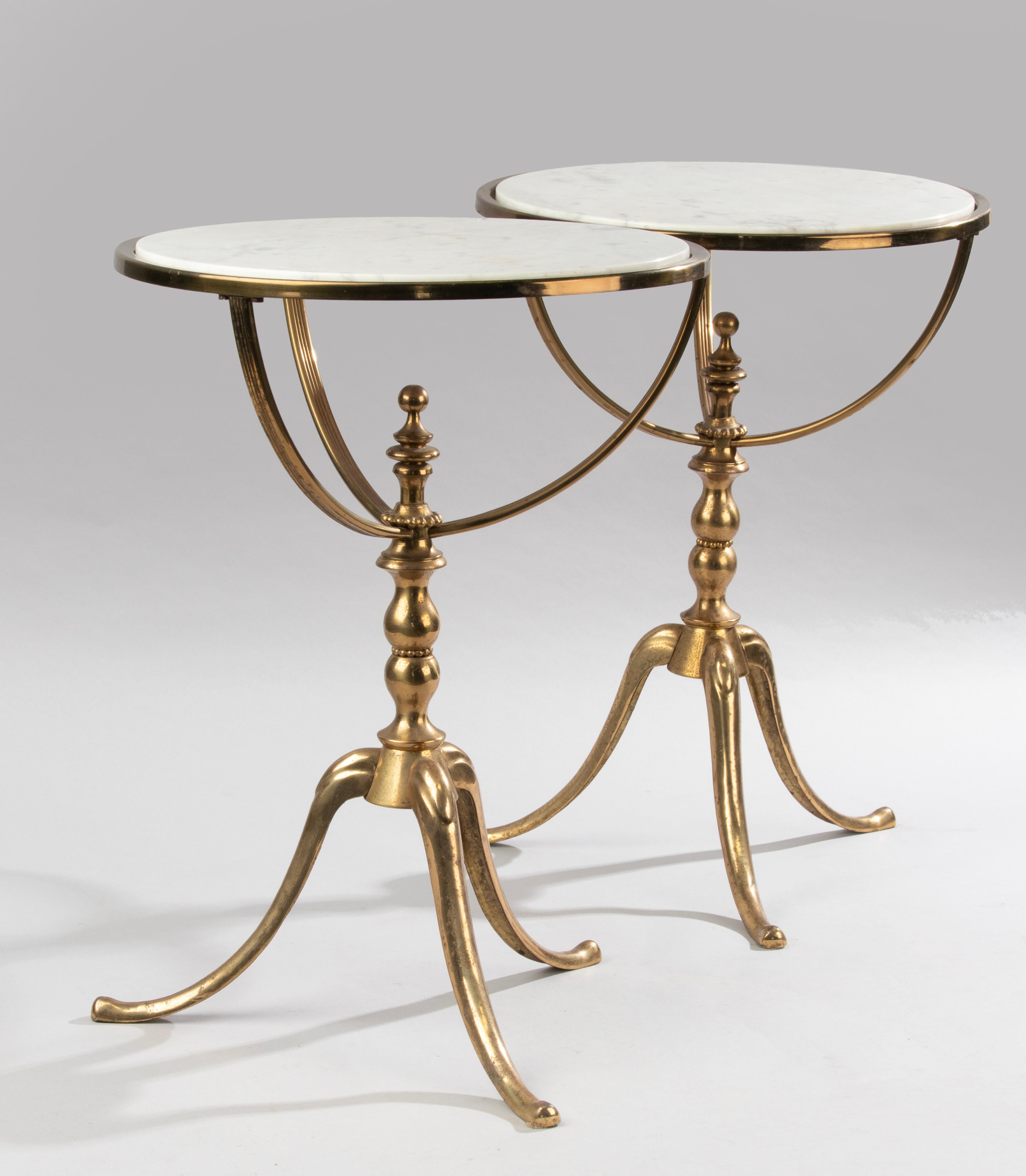 A pair of mid 20th century side tables with a tripod base. The base is made of brass colored metal. On top a Carrara marble base. 
Both tables are in good condition with minor signs of use. 
Little stains on the marble and some wear on the brass