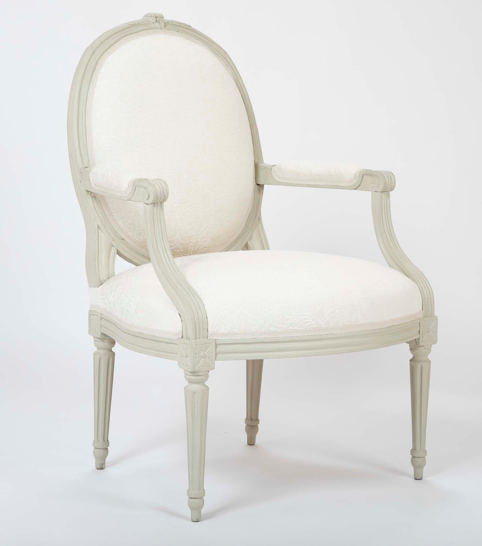 A pair of painted late 19th century Louis XVI style armchairs. Newly upholstered.