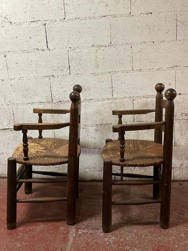 A pair of Dudouyt Armchairs in oak and straw.