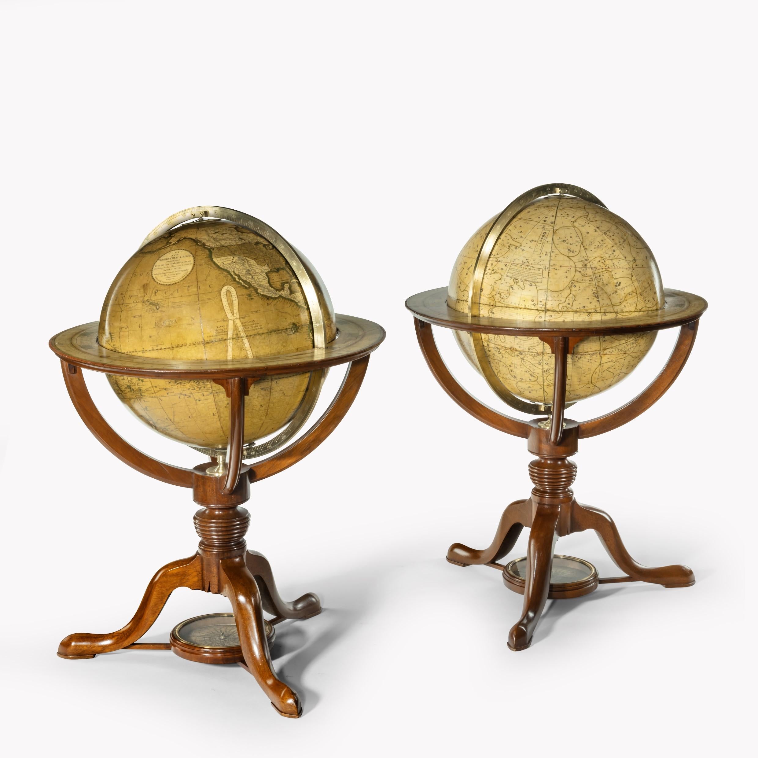 Une paire de globes de table de 12 pouces par G & J Cary, datés de 1800 et 1821, chacun avec des gores peints à la main, placés dans des supports en acajou avec un support tourné reposant sur trois pieds centrés sur les roses de la compagnie.