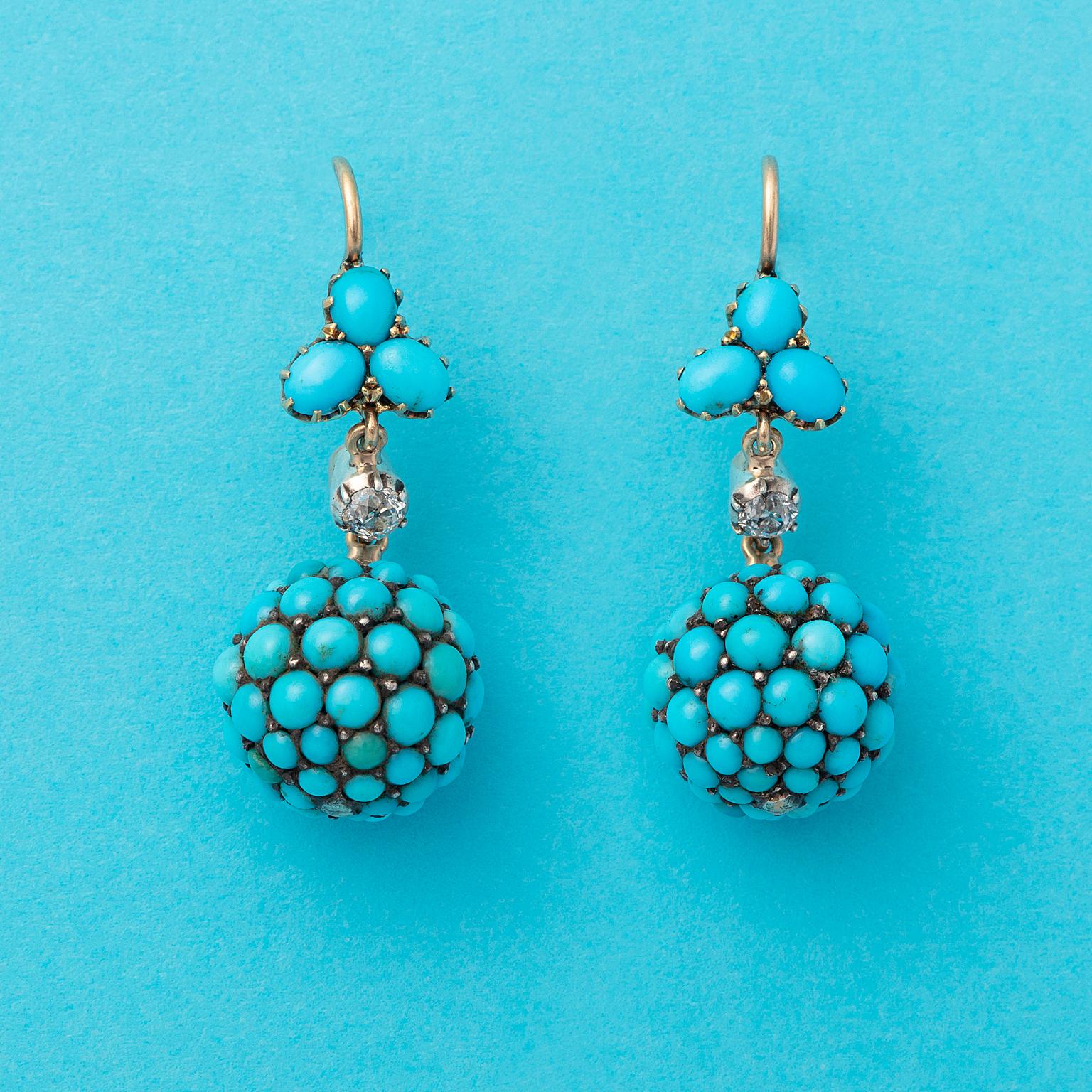 A pair of 14 carat gold earrings, with a little flower with three oval cobochon cut turquoise petals from which suspends a diamond (app. 0.06 ct) set in silver from which  suspends a ball pavé set with cabochon cut turquoises, 19th century.
weight: