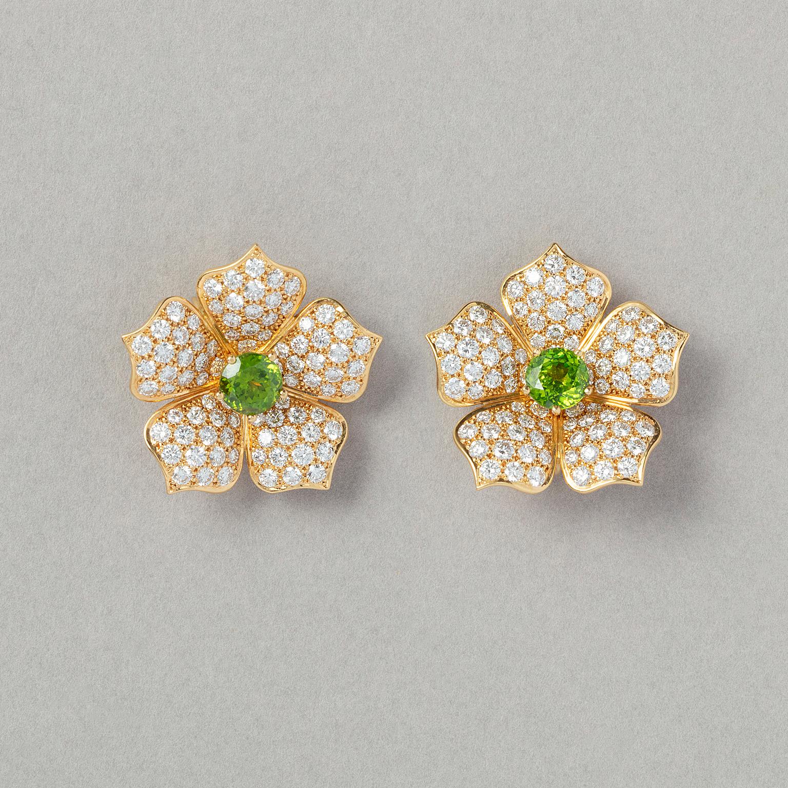 A pair of 18 carat yellow gold lotus flower earrings, each set with a demantoid garnet in a five claw chaton in he centre (app. 2.35 carat in total) surrounded by five flower petals that are pavé set with brilliant cut diamonds (app. 4.63 carat in
