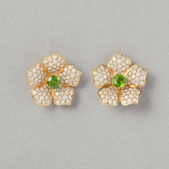 Un paio di fermagli per orecchie in oro 18 carati con diamanti e Demantoide Lotus