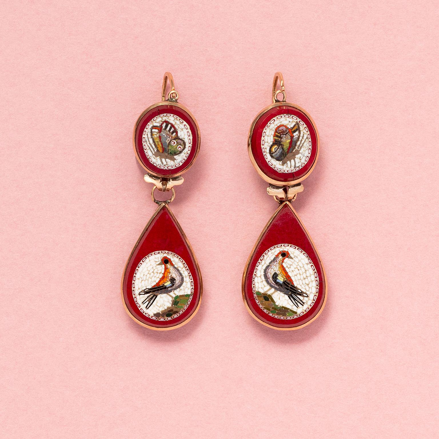 A pair of 18 carat rose gold and micro mosaic earrings, each set with a round plaque with a butterfly on a white background set in red purpurin glass - which imitates obsidian - with a drop shaped red purpurin plaque with a bird on a white