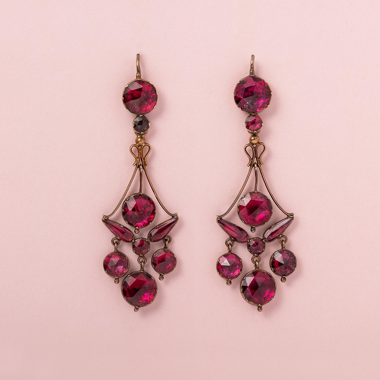 A pair of 18k rose gold girandole earrings with round and pear-shaped rose-cut garnets on pink gold foil, South of France, hallmarked with the  French assay mark for 18k gold between 1838-1919 and French master's mark.

weight: 10.34 g
dimensions: 7