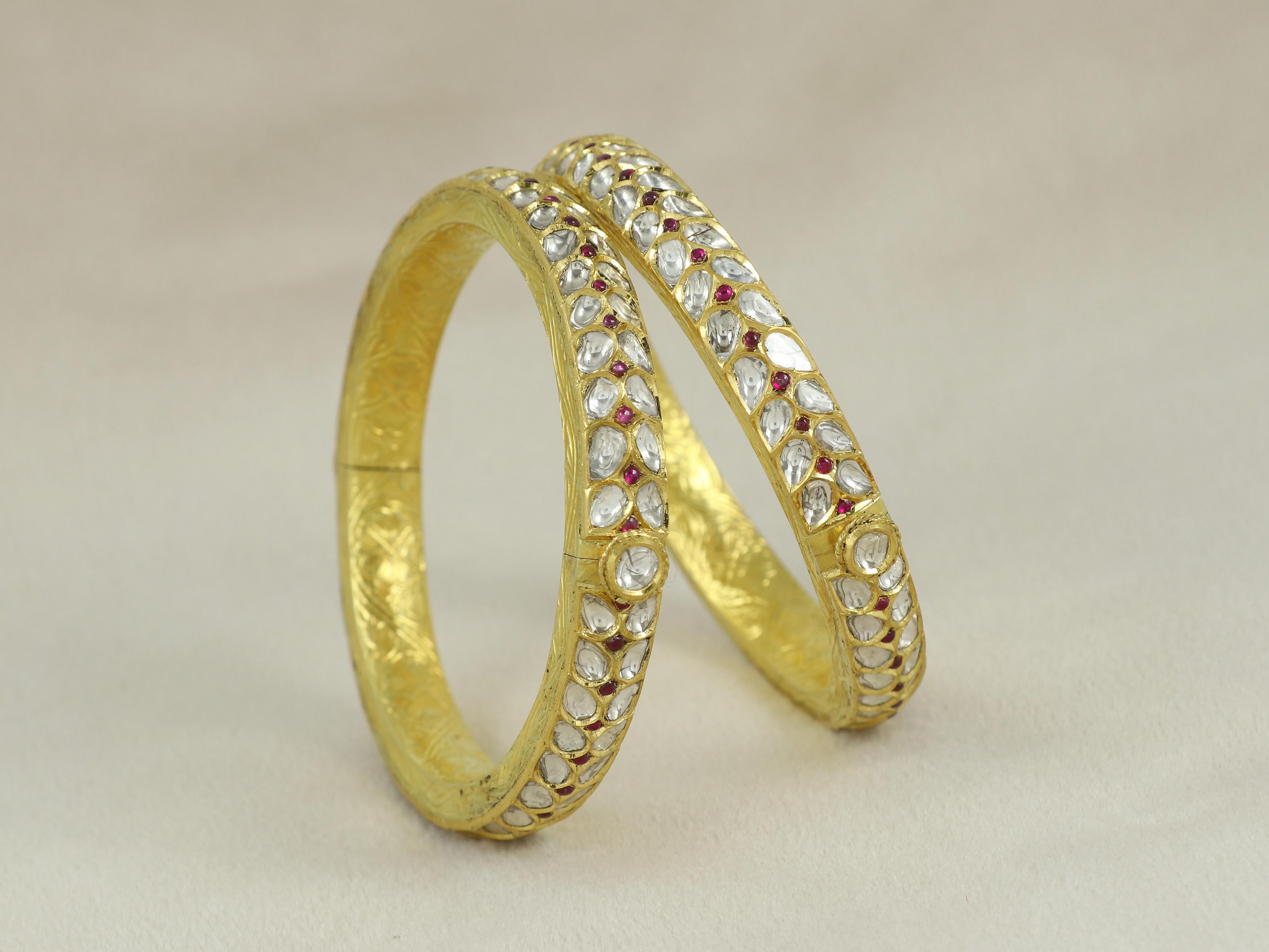 Ein Paar Mughal-Polki-Armreifen aus 18-karätigem Gold, besetzt mit natürlichen Diamant-Polkis. Der Armreif aus Gold wurde am unteren Ende in Form von Blumenadern graviert, die die traditionelle indische Kunst des Meenakari darstellen. Die Armreifen