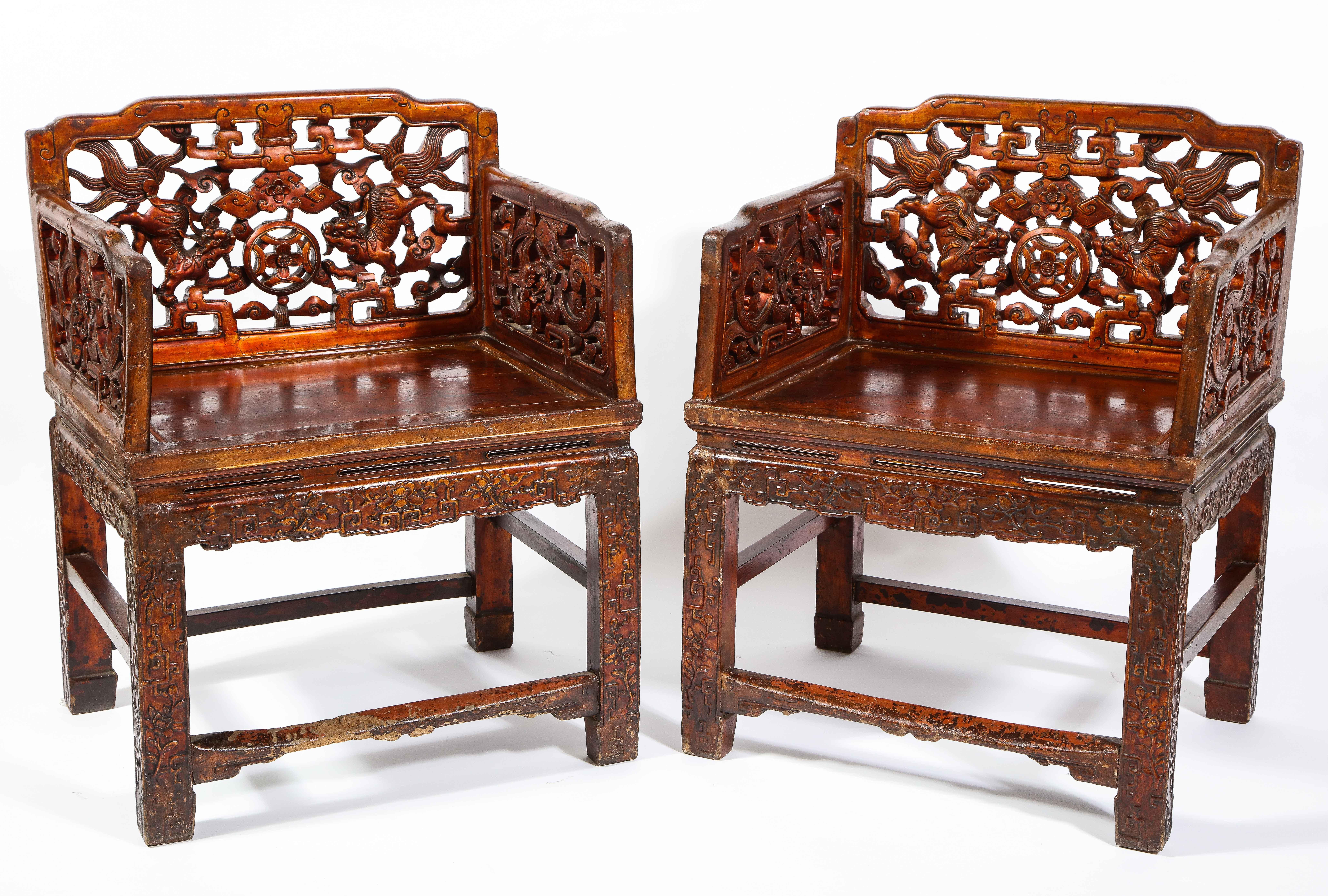 An exceptional and large pair of Qing Dynasty 19th century Chinese lacquered hardwood open work throne chairs decorated with dragons, foo lions, flowers, and vines. Each throne chair is exceptionally hand-carved with meticulous detail and