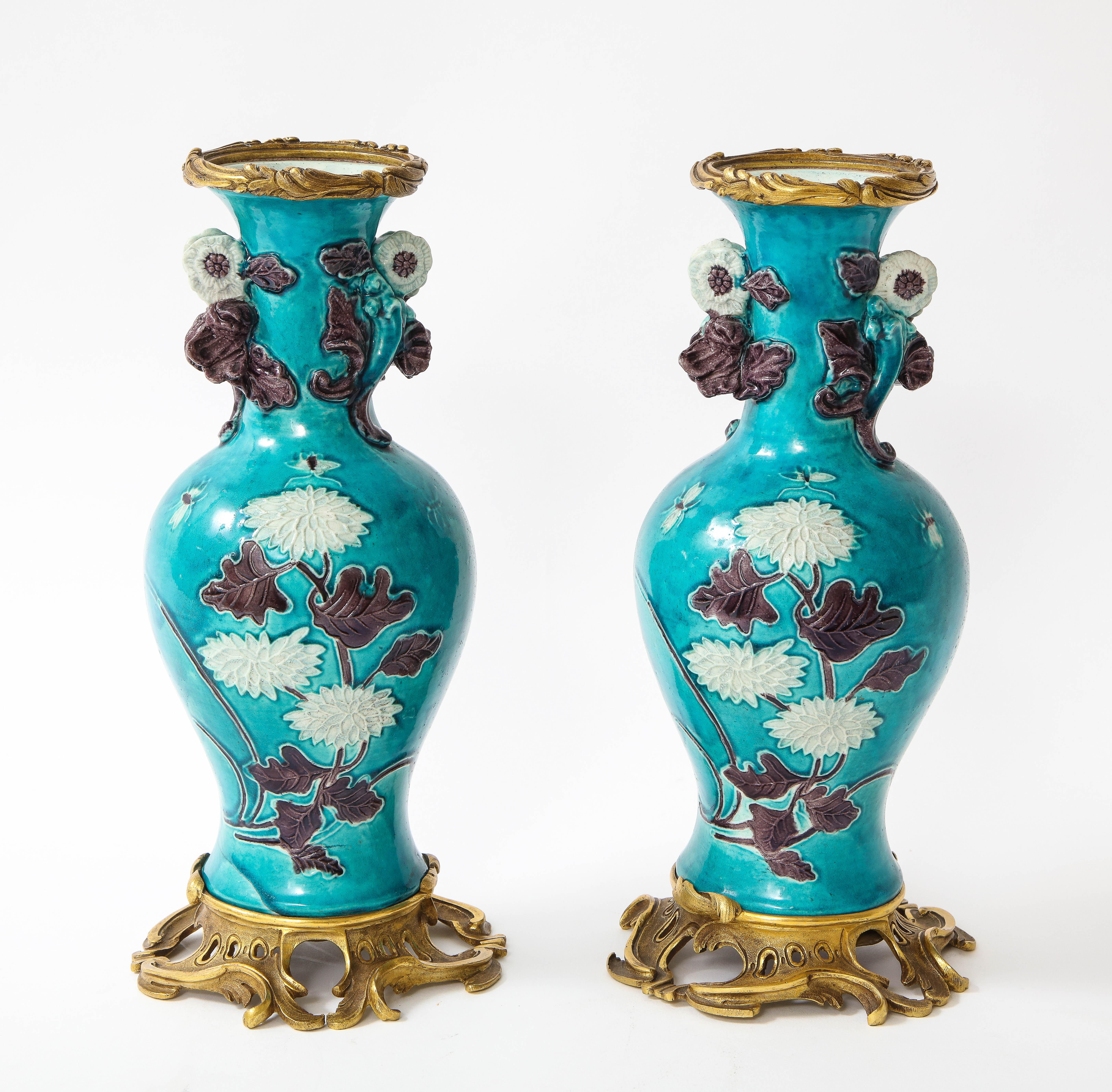 An incredible pair of Louis XVI style 18th century Chinese porcelain vases with 19th century French doré bronze mounts. The porcelain was made in china in the 1700s. The vase is of turquoise ground with dark hand-enamelled purple and white