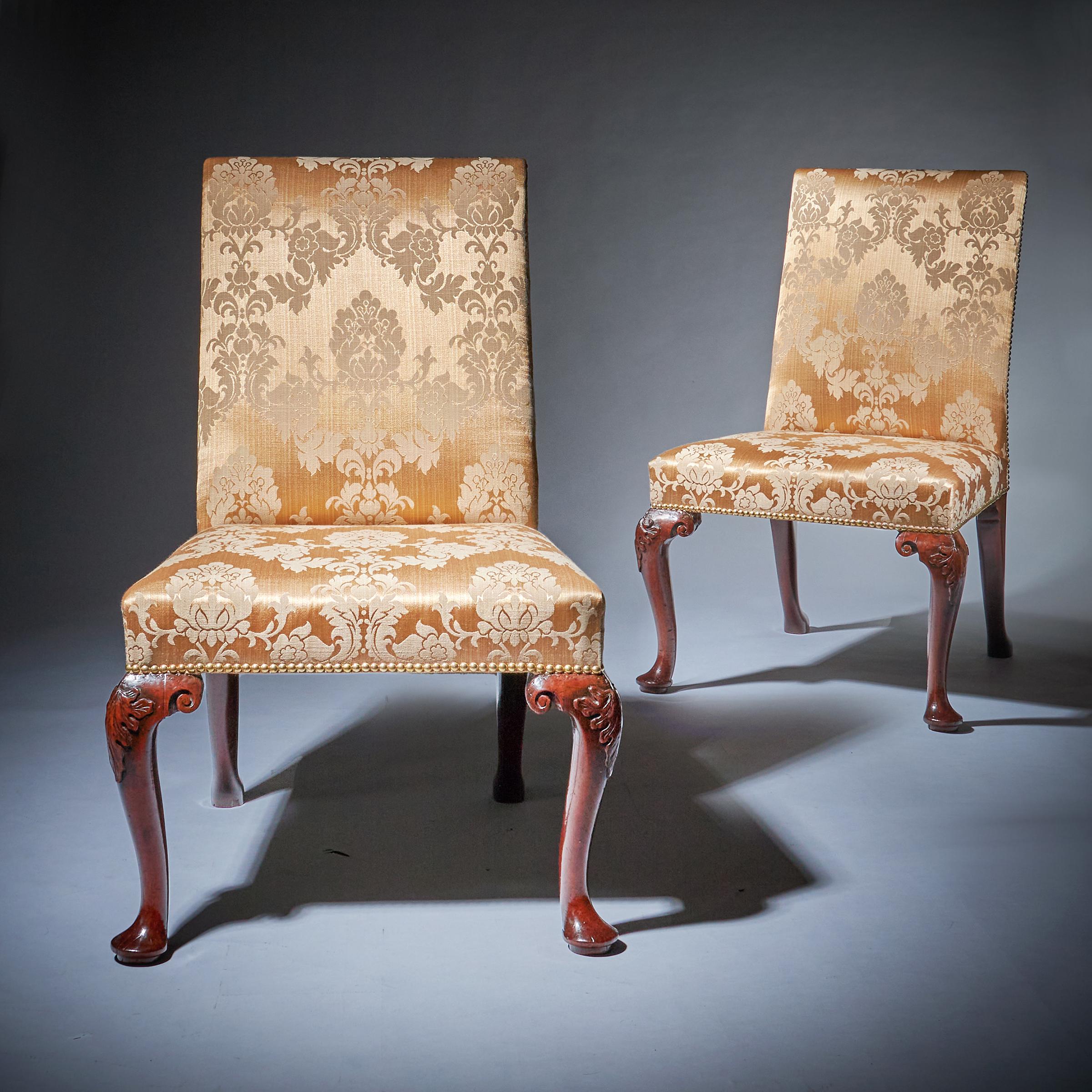 A very attractive and rare pair of 18th century George II mahogany side chairs, circa 1730-1740. England

The high rectangular backs and seats are upholstered in light gold Damask close nailed to beech frames and raised on cabriole legs carved to