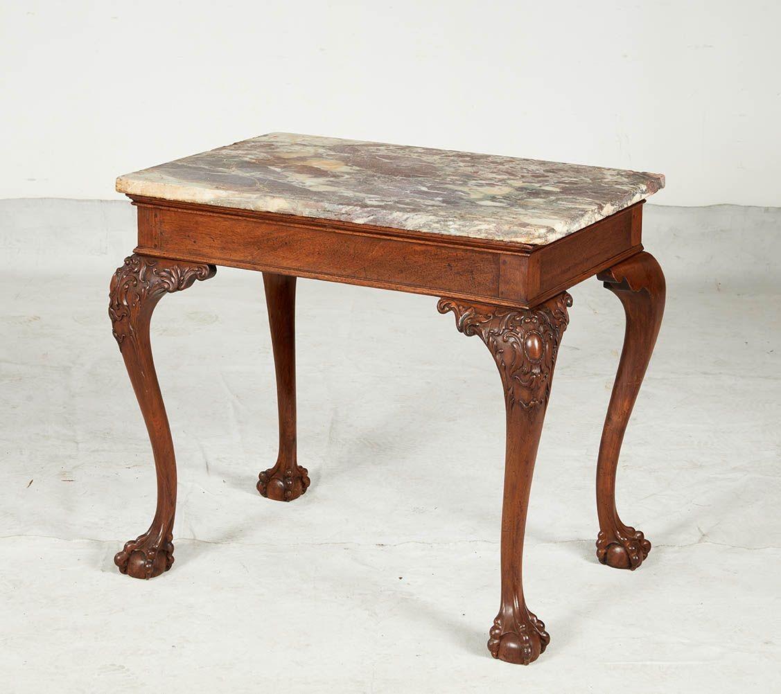 Fine pair of George II mahogany console tables, the original Breche Violette tops over molded apron and standing on acanthus scroll carved legs, the knees with cabochon and foliate carving and standing on boldly carved ball and claw feet, both with