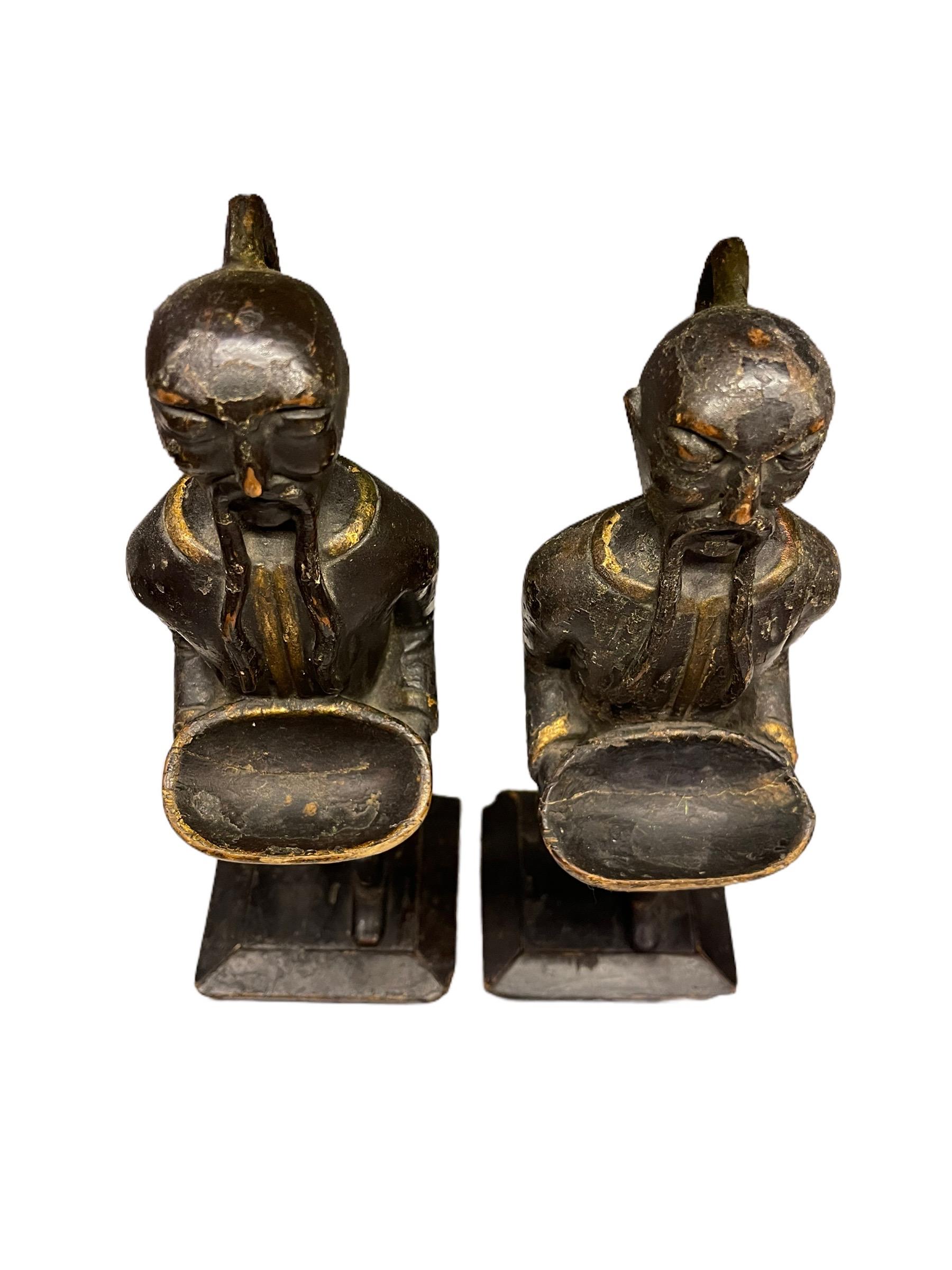 A pair of 18th Century English Chinoiserie carved wood ring holders modeled after Asian men. The pieces are polychromed and gold gilded. Both are holding trays which are used to place the rings.
     