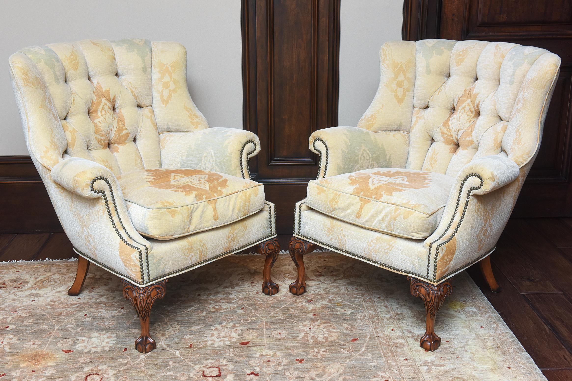 Paire de fauteuils à oreilles anglais du XVIIIe siècle, fabriqués avec expertise en noyer et dotés de coussins en duvet nouvellement rembourrés. Les chaises sont habillées d'un luxueux tissu chenille design, ajoutant une touche d'élégance