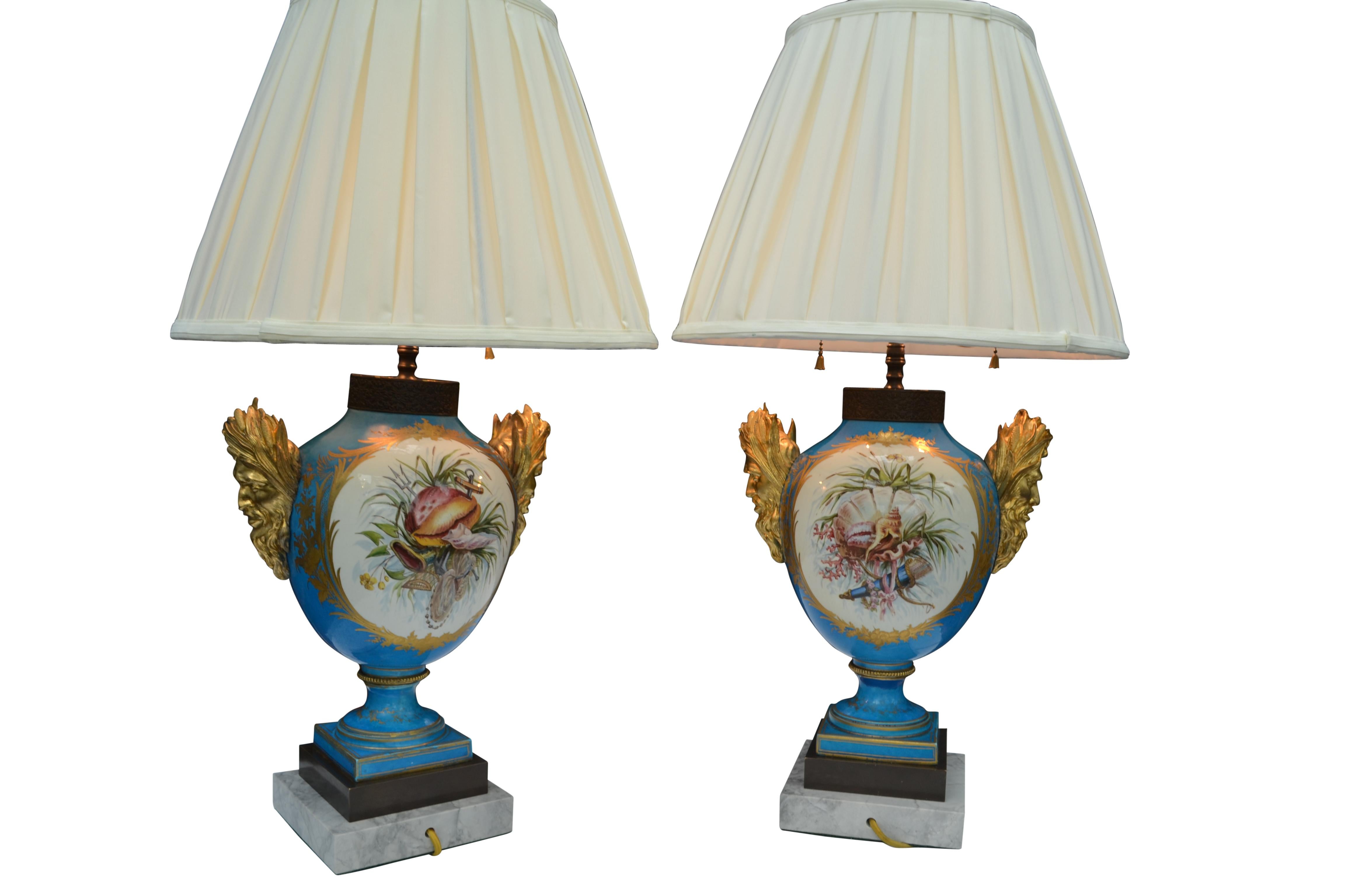 A truly fine pair of blue celeste ground Sèvres Porcelain baluster vases with exceptional gilt bronze mascaron handles. Designed in the Rococo style, the vases display hand painted panels depicting scenes from Greek Mythology with Poseidon and
