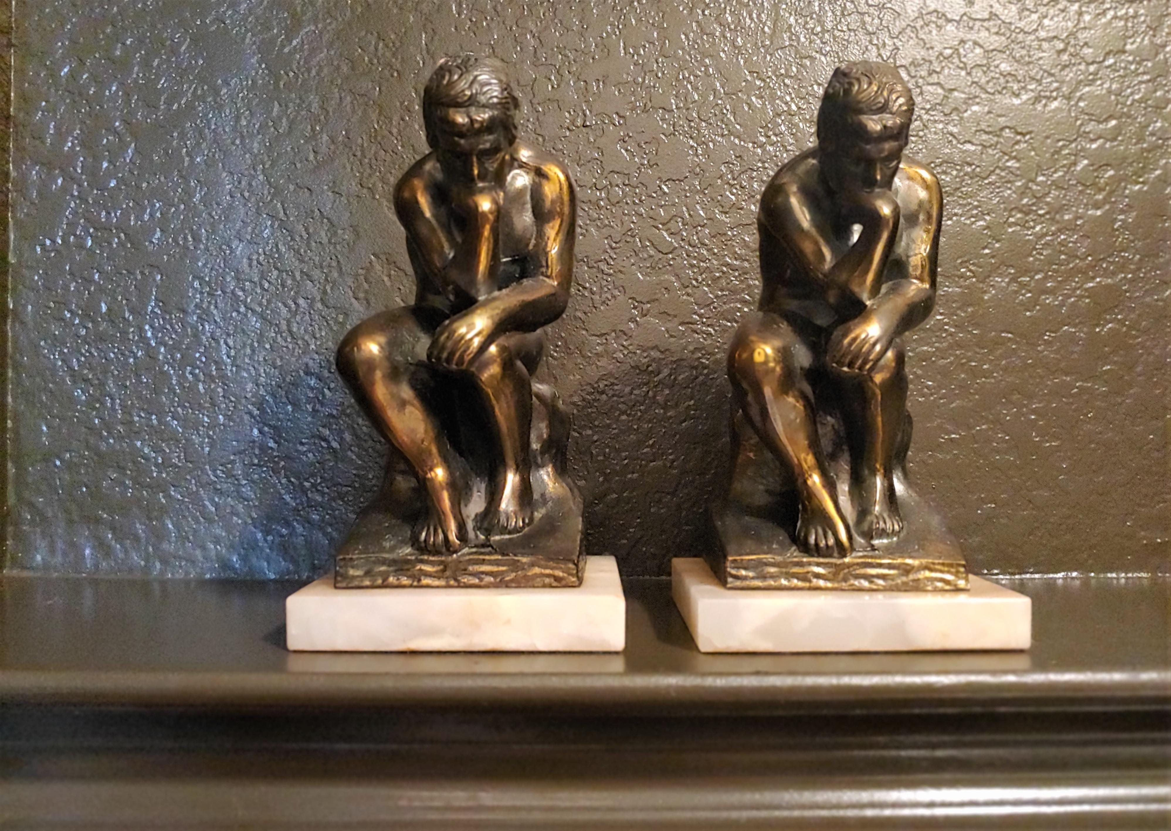 This pair of vintage brass and white onyx bookends dates to the 1920s and are clearly inspired by Rodin's 'The Thinker.' From time to time, similar bookends will surface, but differing significantly in craftsmanship. This pair is stunning and rare